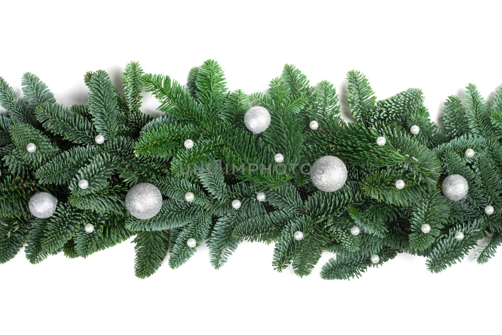 Christmas Border frame of natural noble fir tree branches and silver baubles isolated on white background