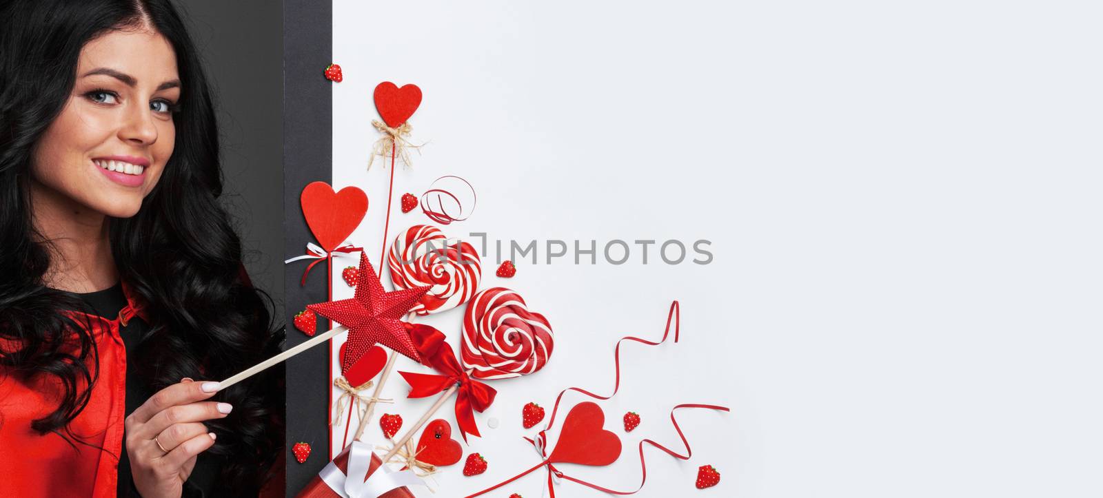 Woman with magic wand near Valentines day decoration and heart shaped lollipops isolated on white background