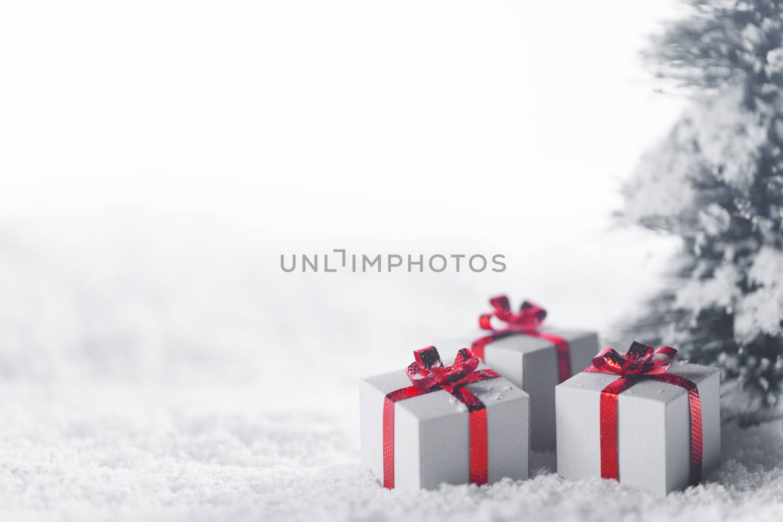 Christmas tree and gift boxes on snow isolated on white background
