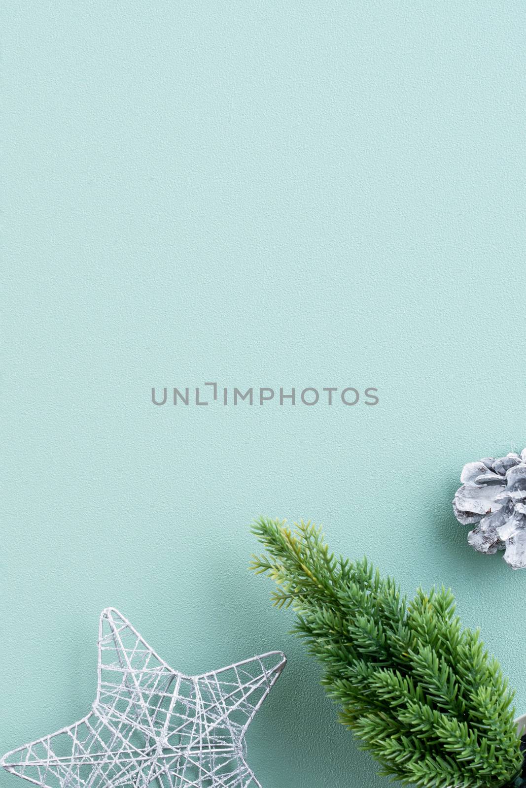 Top view of Christmas holiday decoration ornament composition with Christmas tree, gift star, gingerbread man flat lay with copy space isolated on green background.