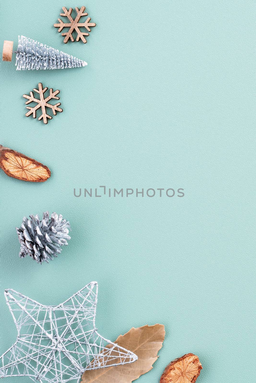 Top view of Christmas holiday decoration ornament composition with Christmas tree, gift star, gingerbread man flat lay with copy space isolated on green background.