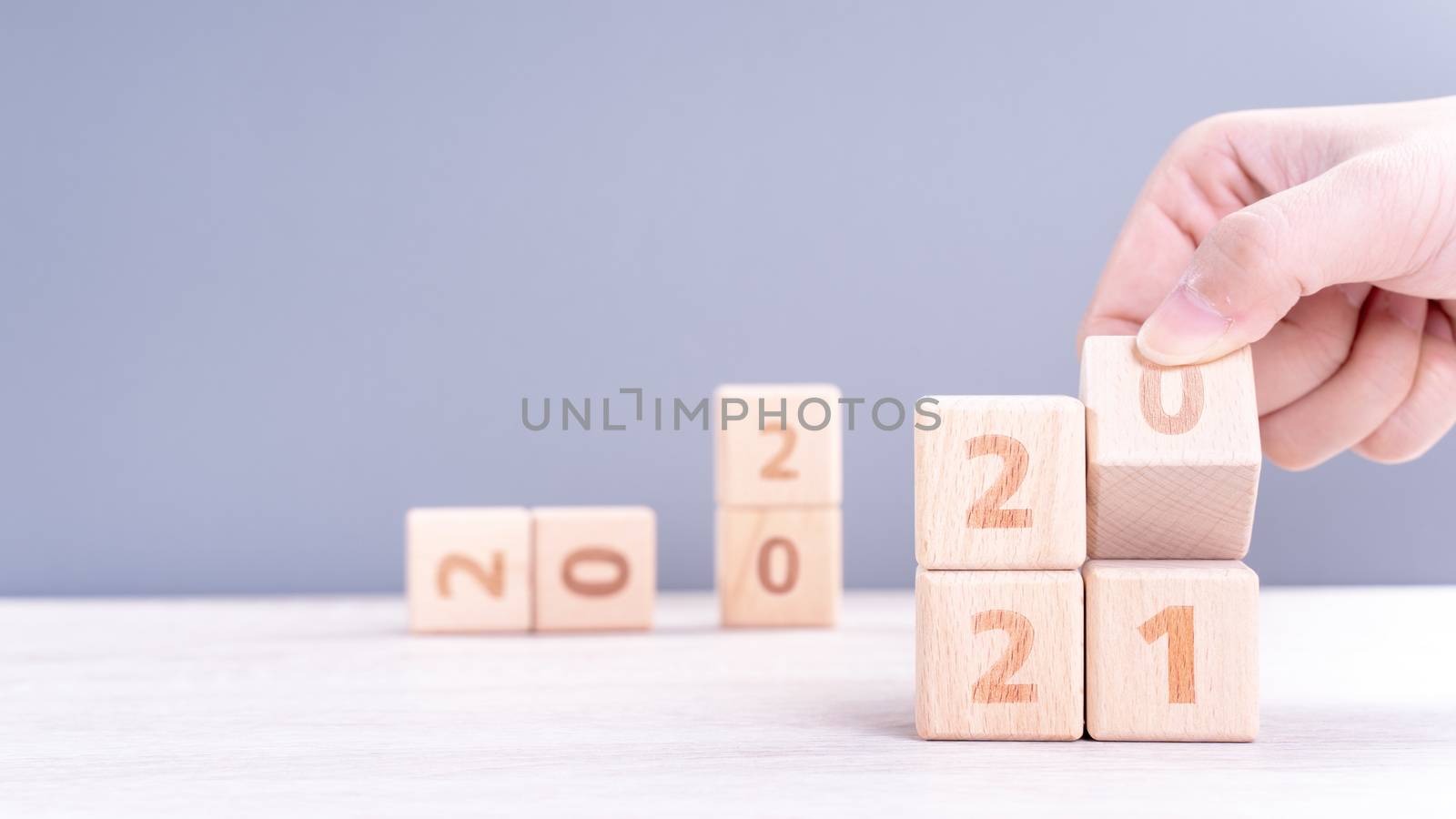2021 New Year abstract design concept - Number wood block cubes isolated on wooden table and light mist blue background.