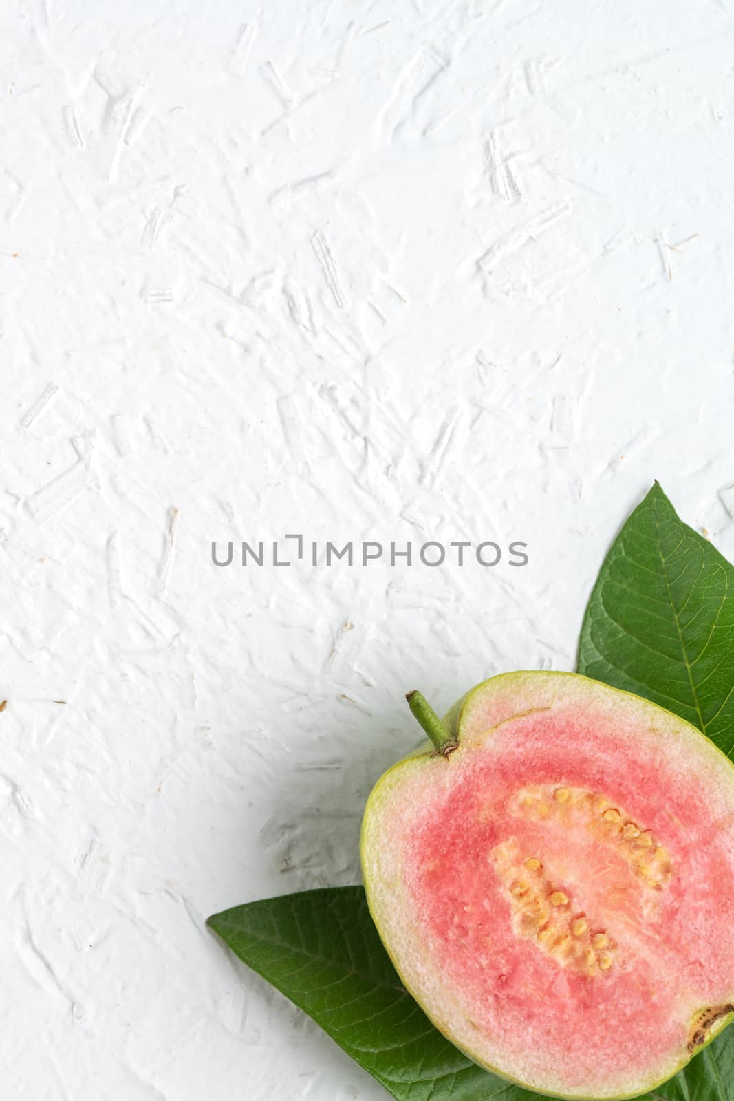 Top view, flat lay of delicious beautiful Red guava with fresh green leaves isolated on white table background, studio overhead table shot with copy space.
