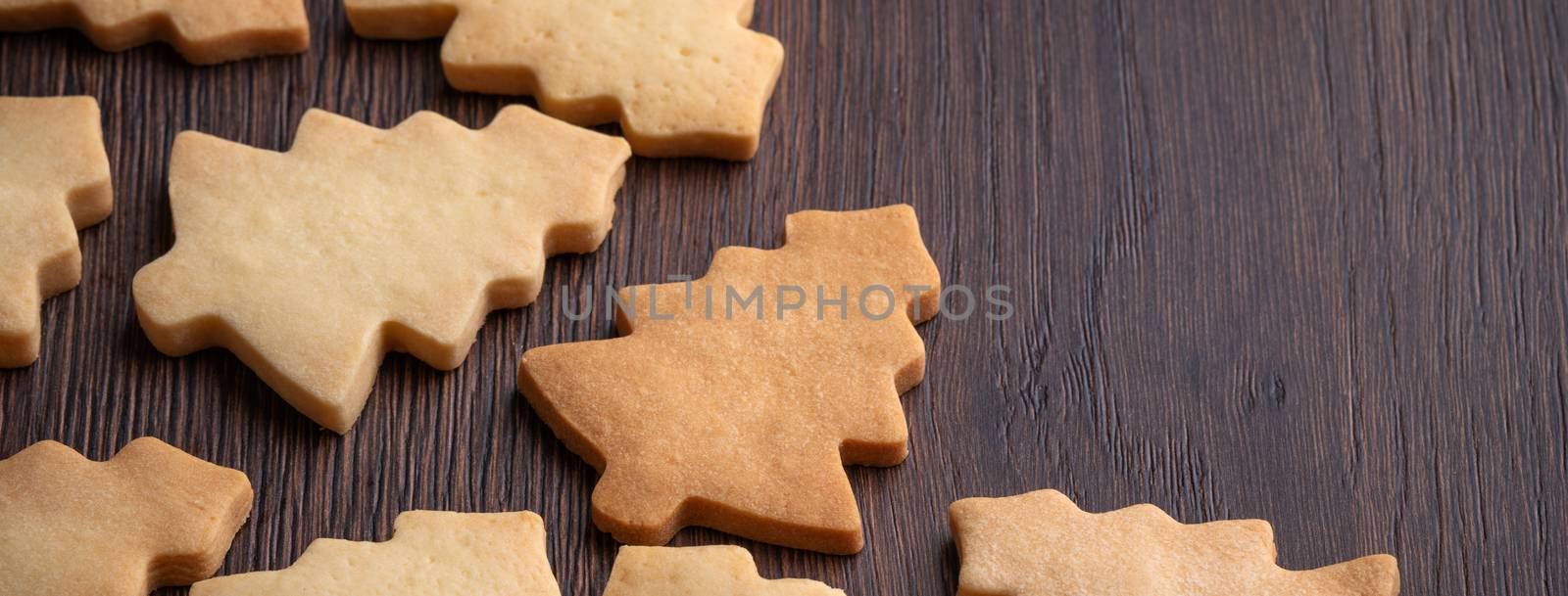 Close up of plain flavor gingerbread Christmas tree cookie on wooden table background. Food for Christmas holiday celebration.