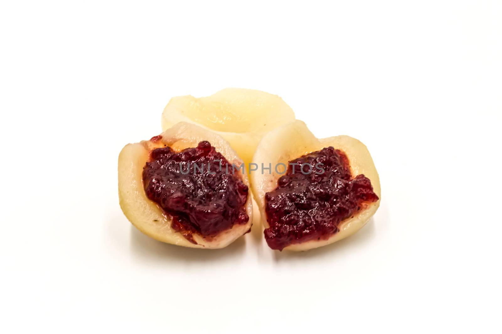 Pear cooked with lingonberry jam on a white background