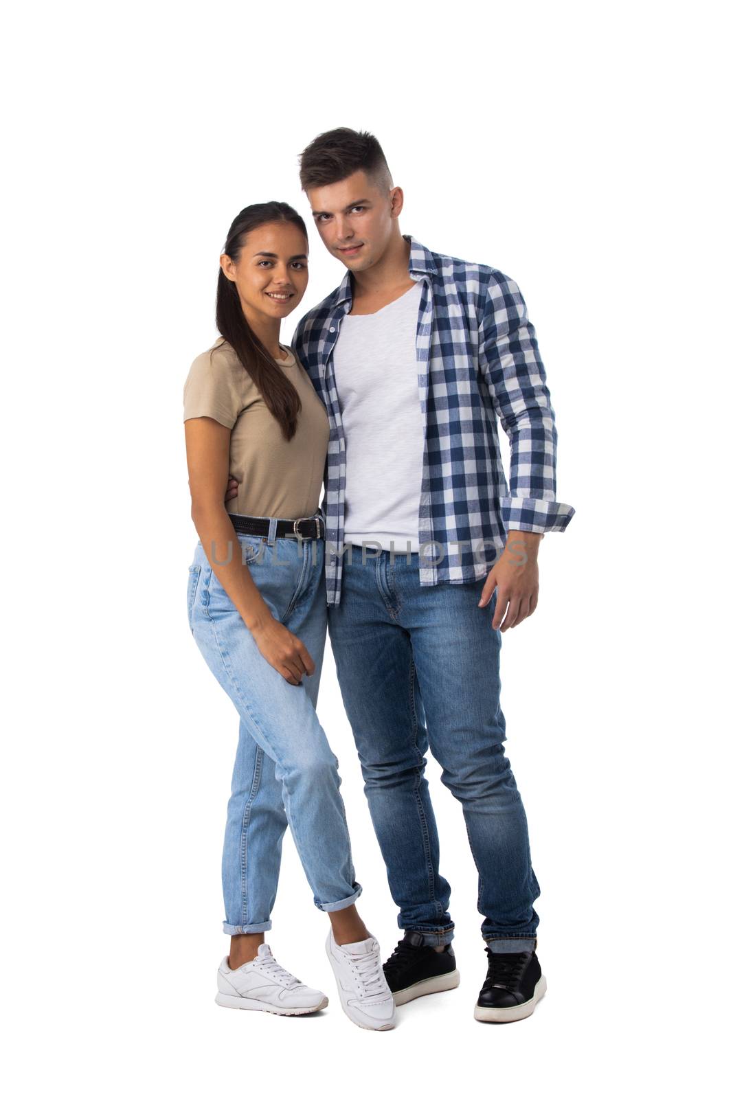 Smiling young couple embracing and standing full length isolated on white background