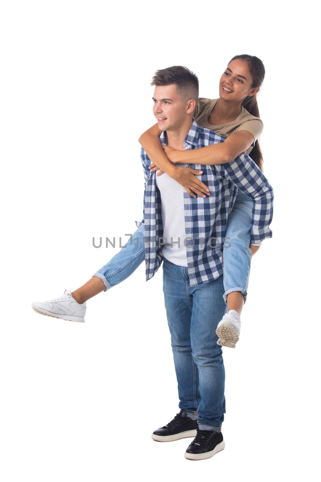 Young happy couple with her at piggyback ride isolated on white background, casual people