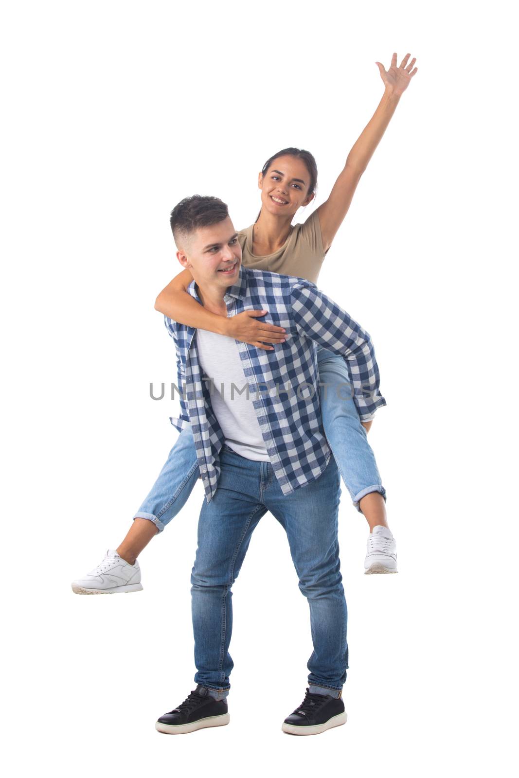 Young happy couple with her at piggyback ride isolated on white background, casual people