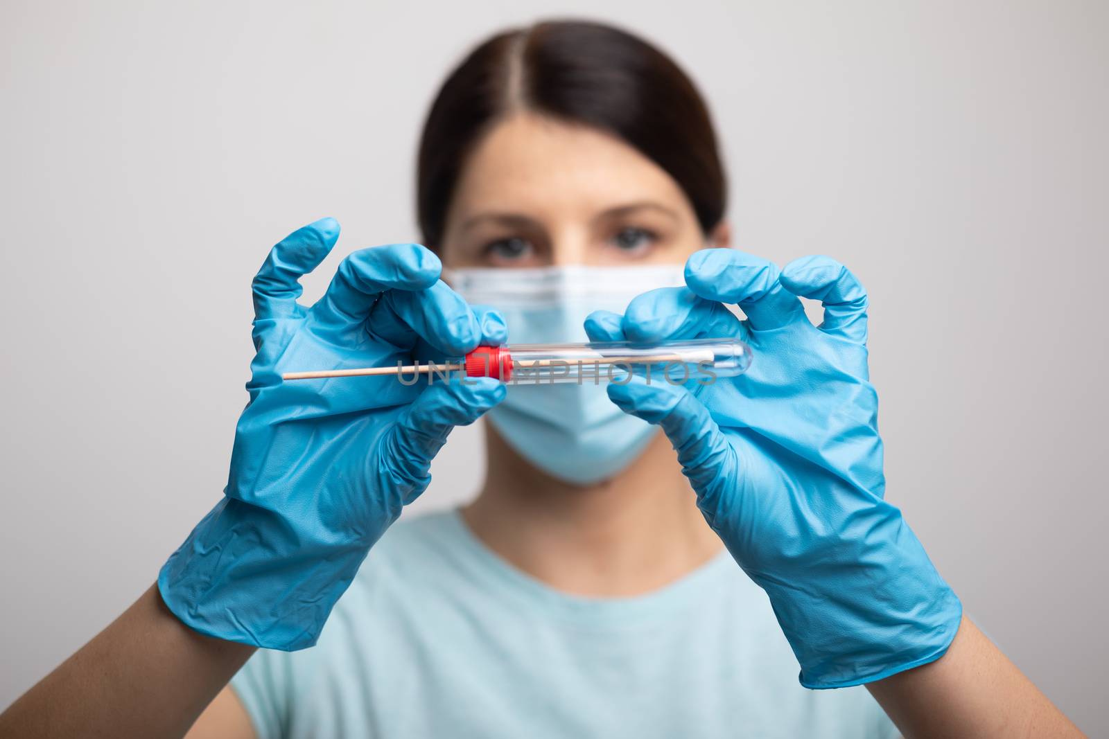 Medical healthcare nurse holding Coronavirus COVID-19 swab test kit, PPE protective mask and gloves, tube for taking OP NP patient specimen sample, PCR DNA RNA testing protocol process stock photo