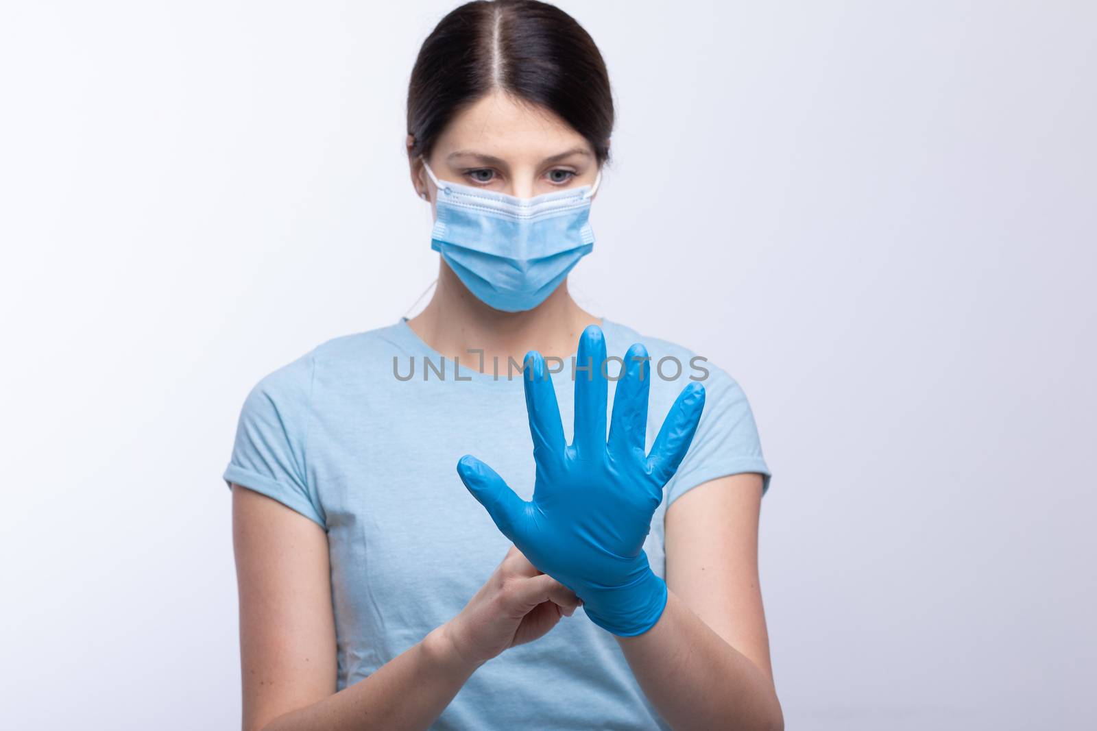 Nurse with face mask wear and checking protective gloves by adamr