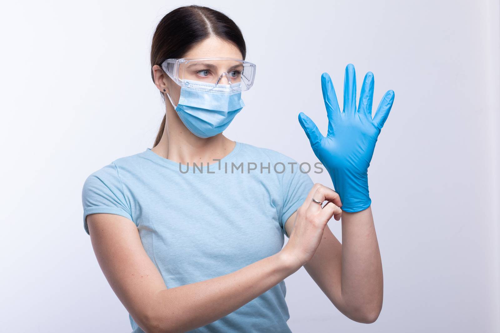 Nurse or doctor wearing and checking protective equipment agains by adamr