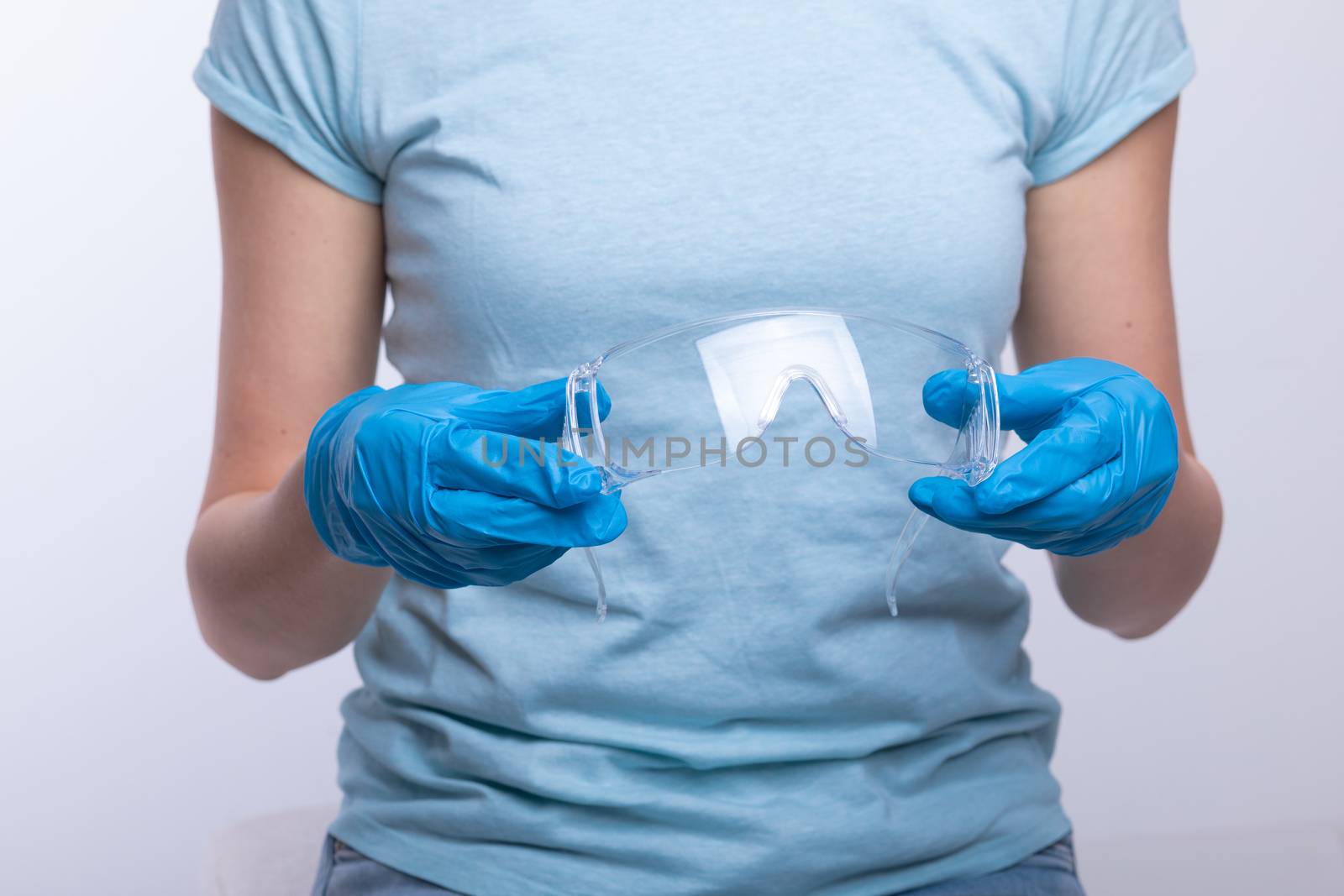 Nurse or doctor wearing and checking protective equipment agains by adamr