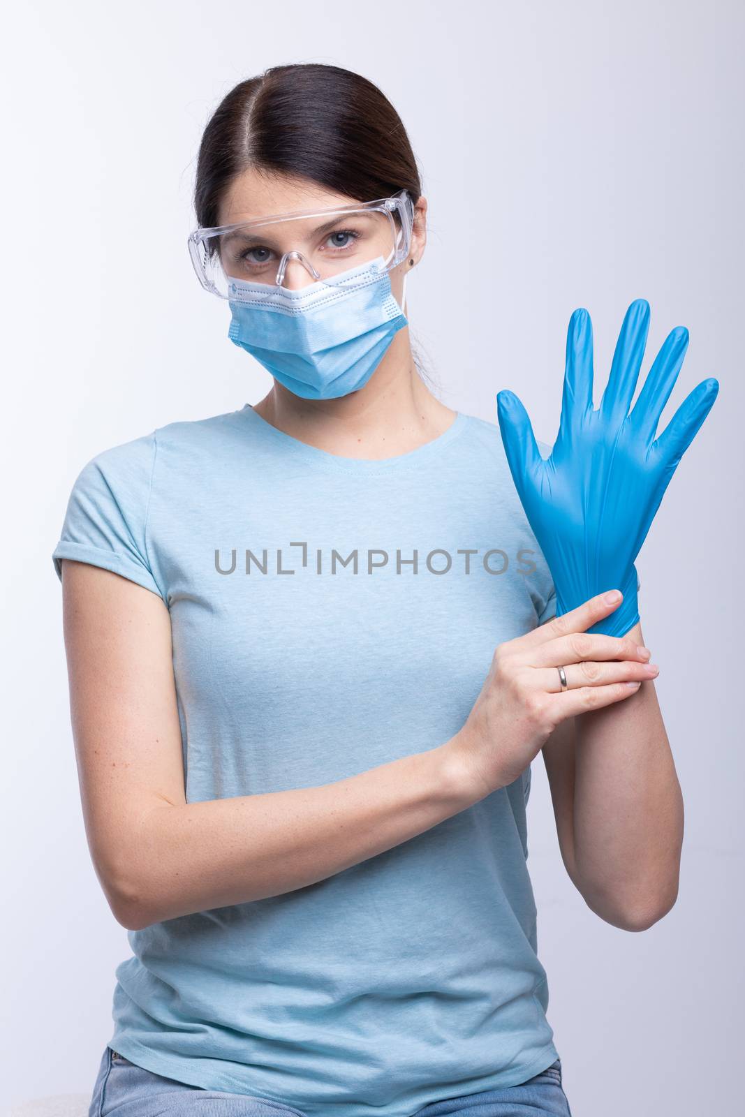 Nurse or doctor wearing and checking protective equipment against viruses and bacterial disease stock photo