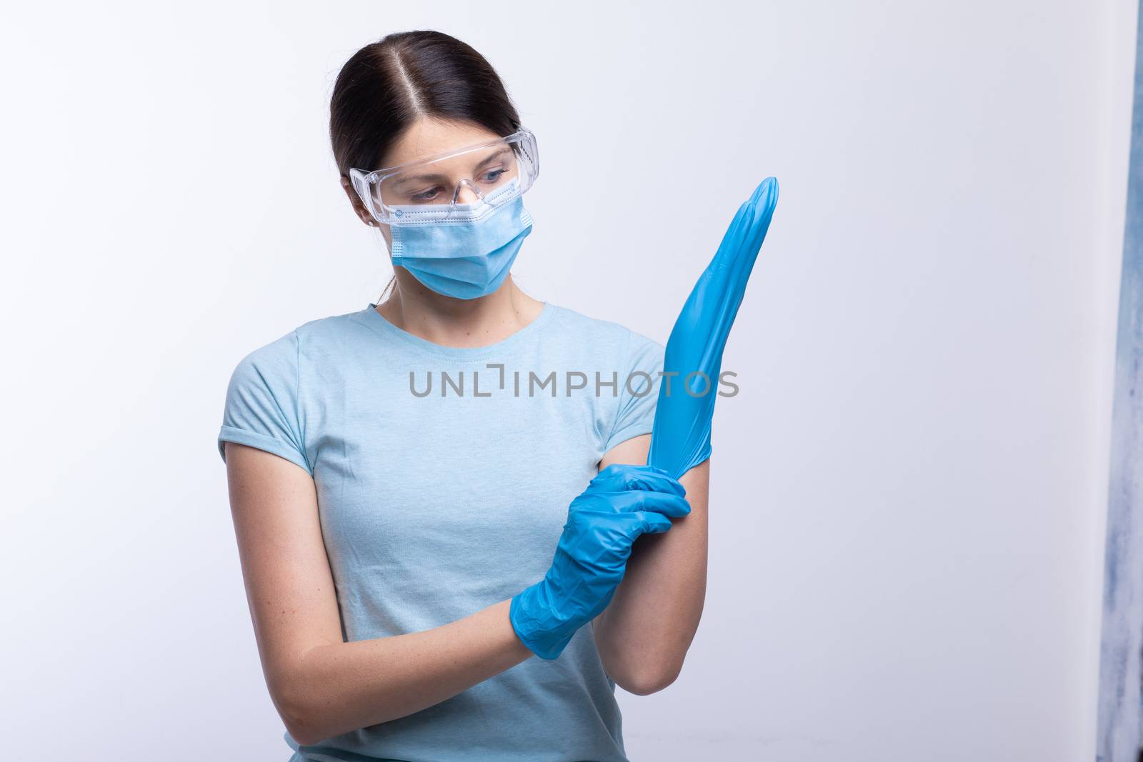 Nurse or doctor wearing and checking protective equipment against viruses and bacterial disease stock photo