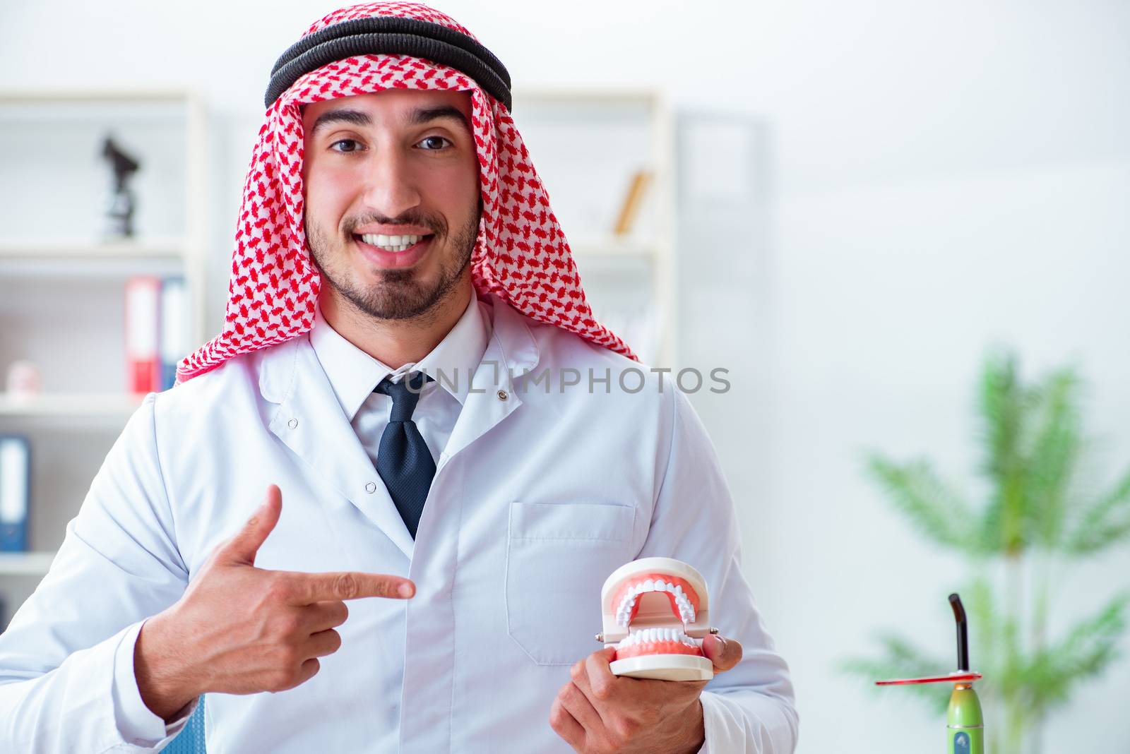 Arab dentist working on new teeth implant by Elnur