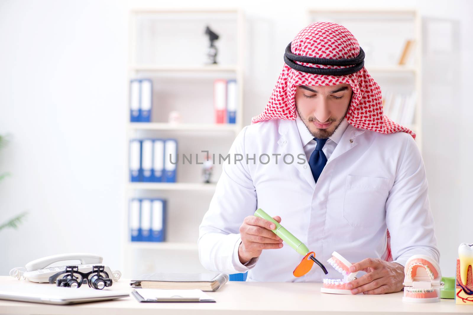 Arab dentist working on new teeth implant by Elnur