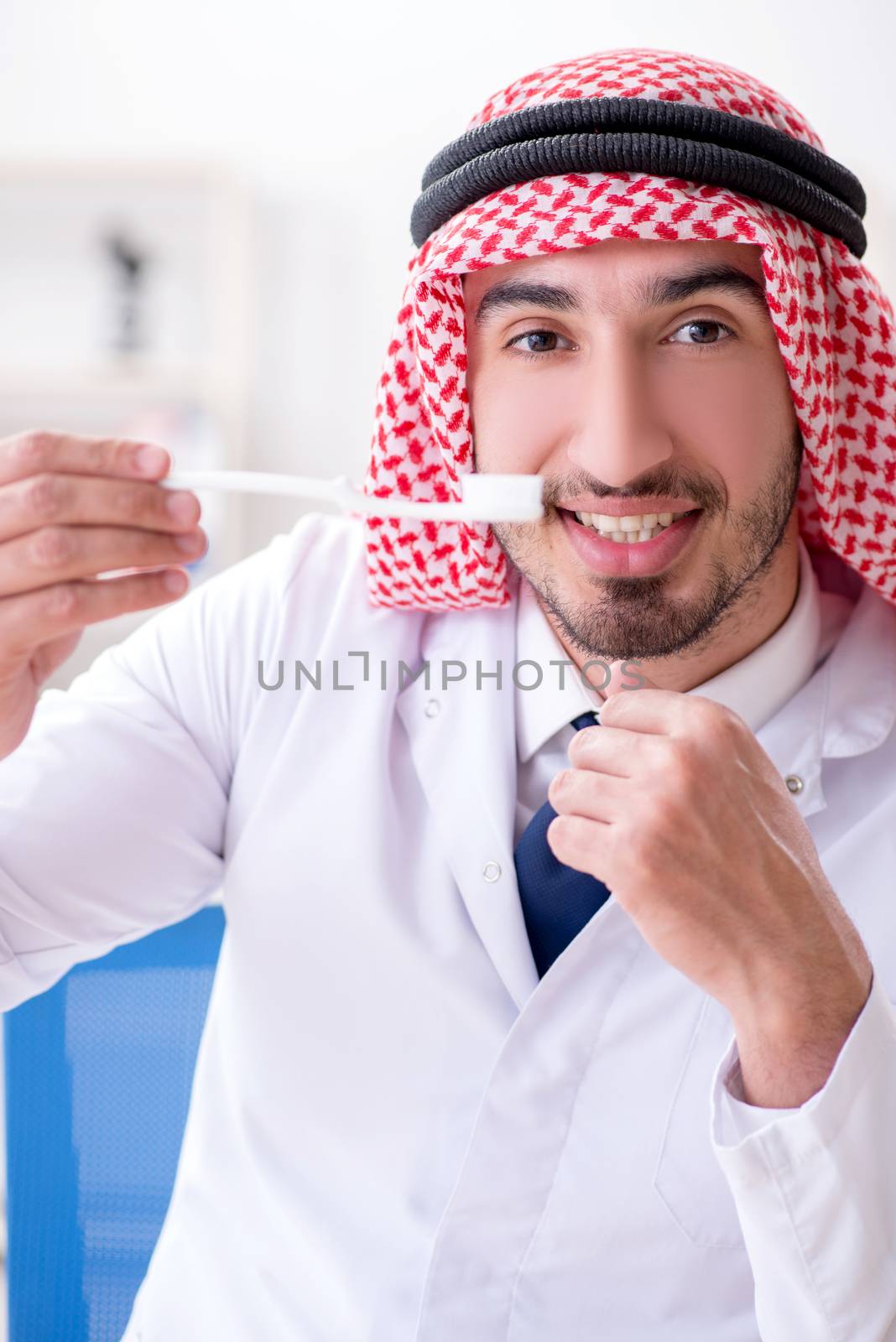 Arab dentist working on new teeth implant by Elnur