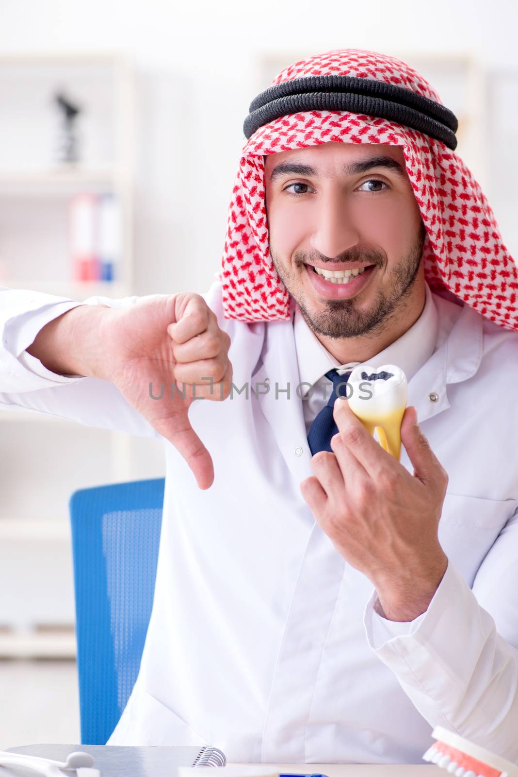 Arab dentist working on new teeth implant by Elnur