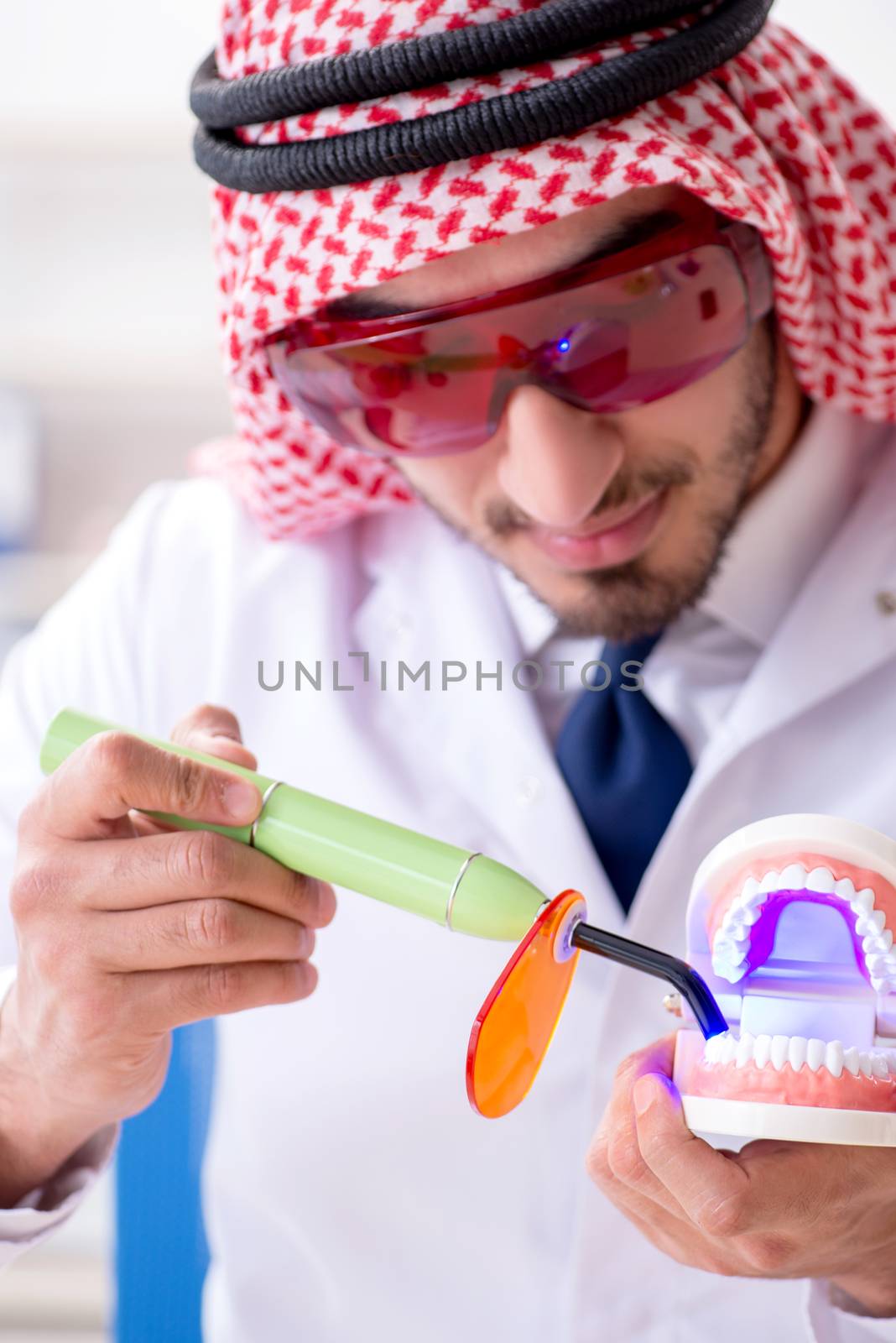 Arab dentist working on new teeth implant by Elnur