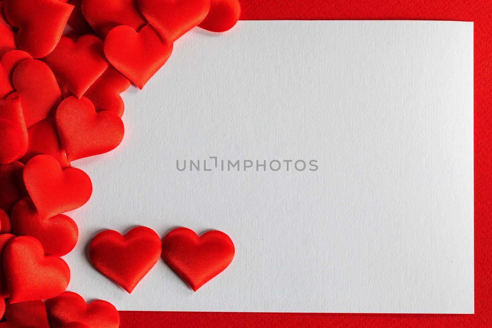 Valentine's day many red silk hearts background , border frame with white card with copy space, love concept