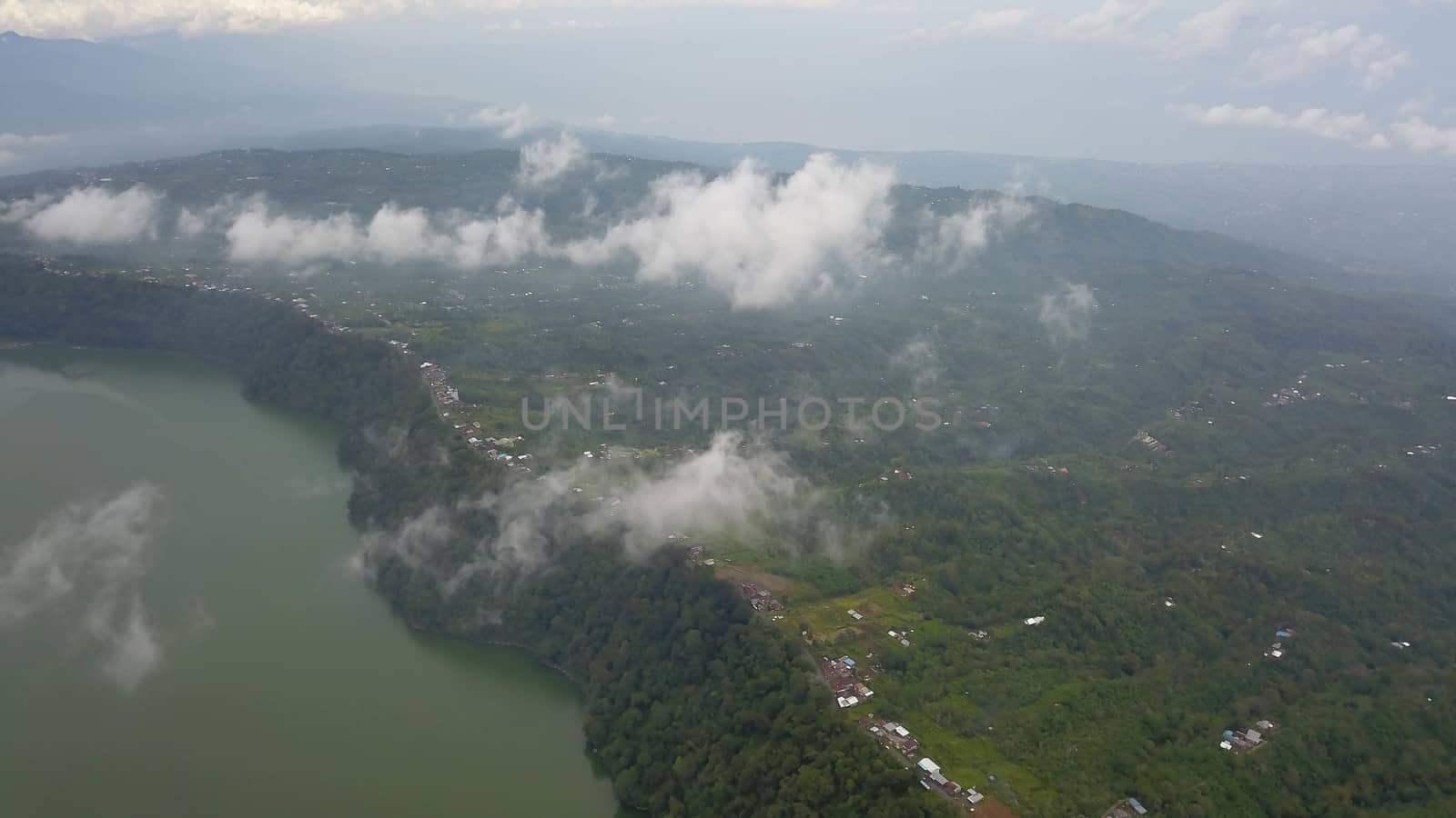 Tropical landscape with mount, mountain Danau Buyan lake and village in distance by blue sky on Bali, Indonesia.