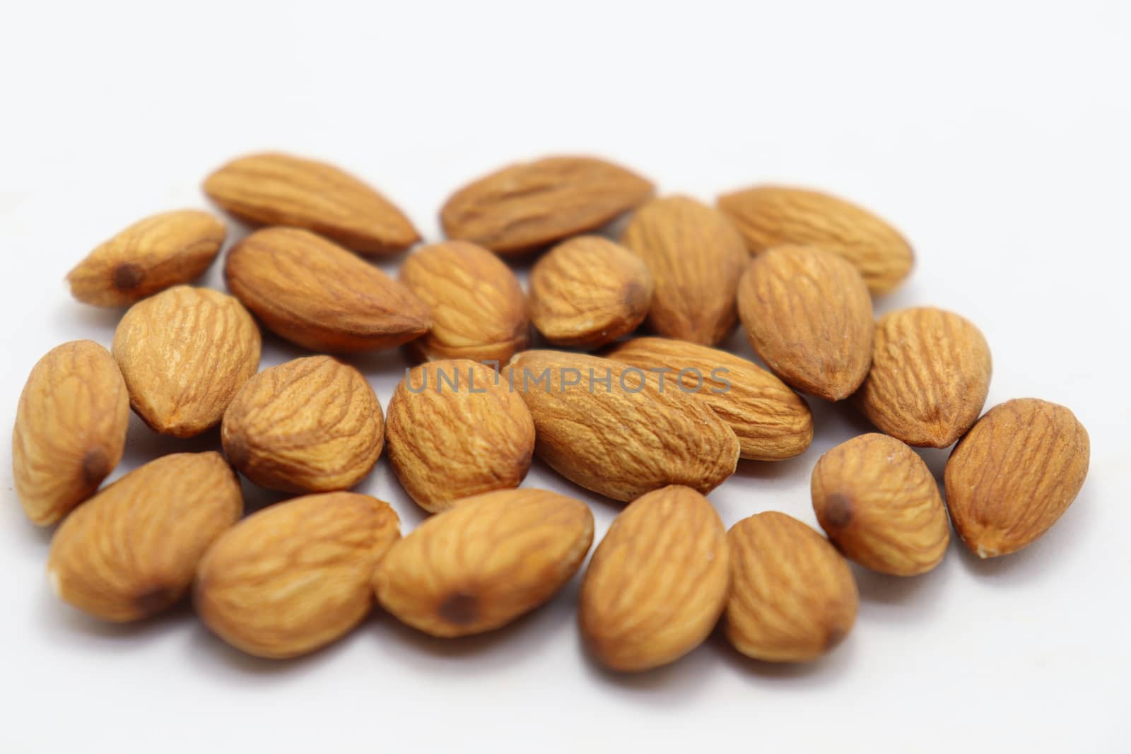 tasty and healthy brown colored almond stock on white background