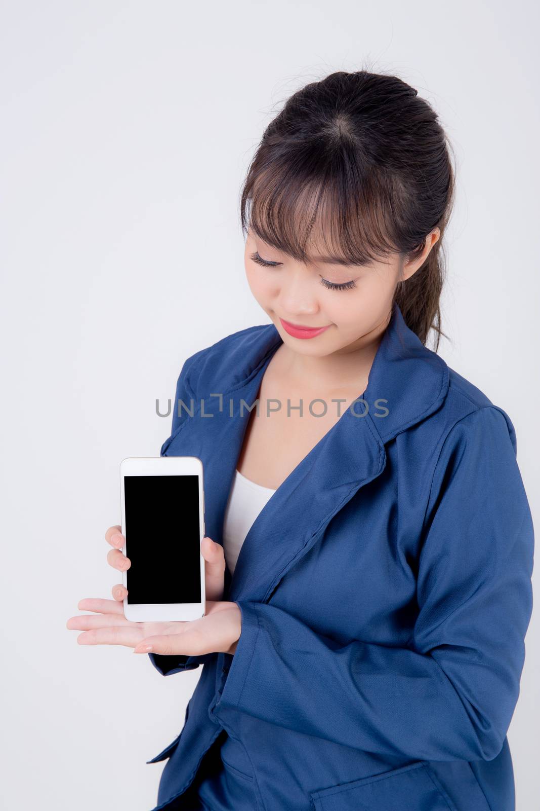 Beautiful portrait young business asian woman show blank smart mobile phone isolated on white background, businesswoman presenting smartphone for advertising, girl holding phone, communication concept.