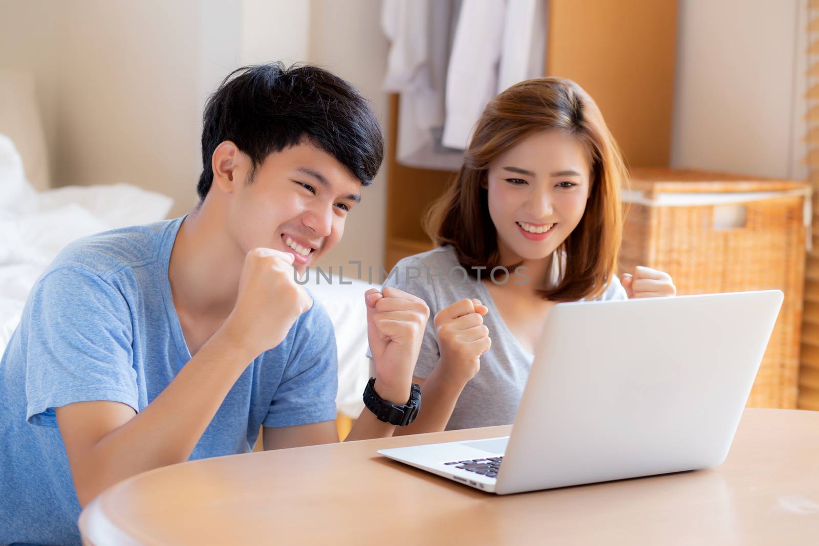 Beautiful portrait young asian couple working laptop with smile  by nnudoo