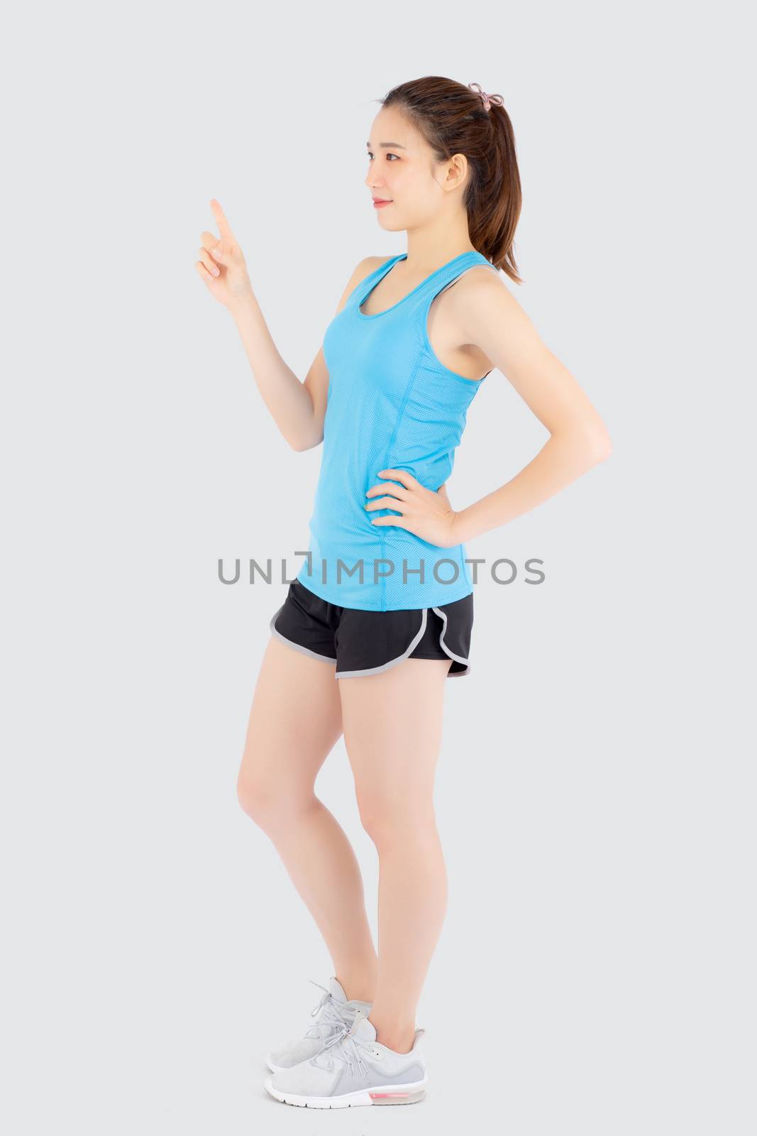 Beautiful portrait young asian woman in sport workout confident pointing and presenting and show something isolated on white background, asia girl exercise for fit with health and wellness concept.