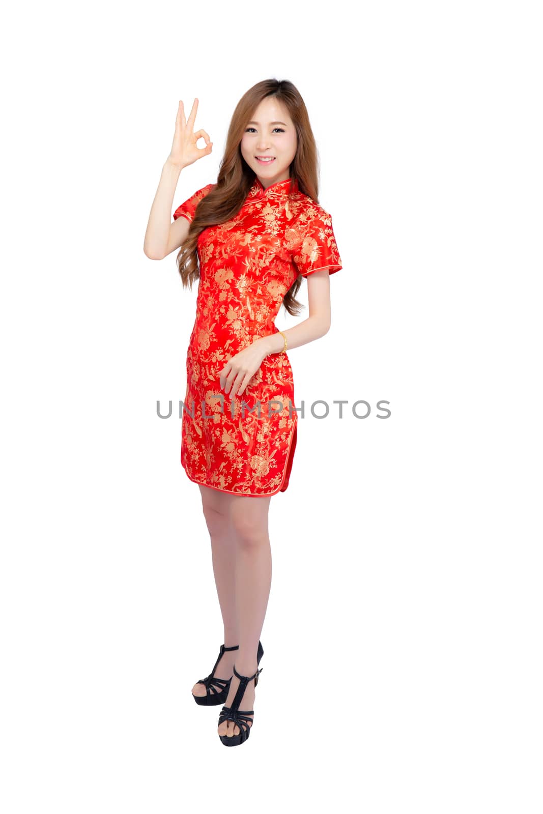 Beautiful portrait happy Chinese New Year young asian woman wear cheongsam fashion smile and cheerful with gesture ok and greeting isolated on white background, festival and celebrate concept.