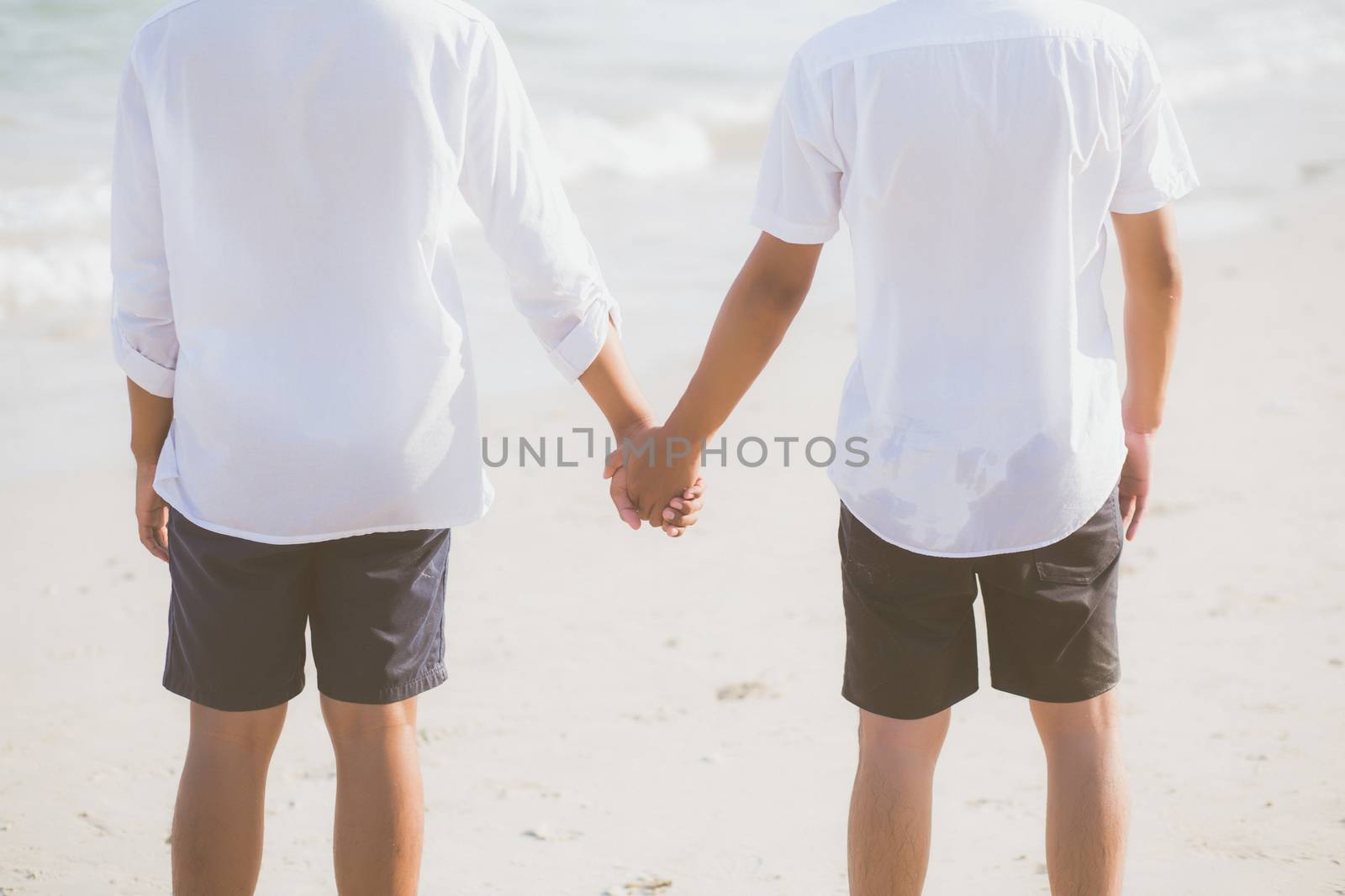 Closeup asian gay couple holding hands together on the beach with relax and leisure in summer, LGBT homosexual legal two man happy and romantic in vacation, relationship sex lover concept.