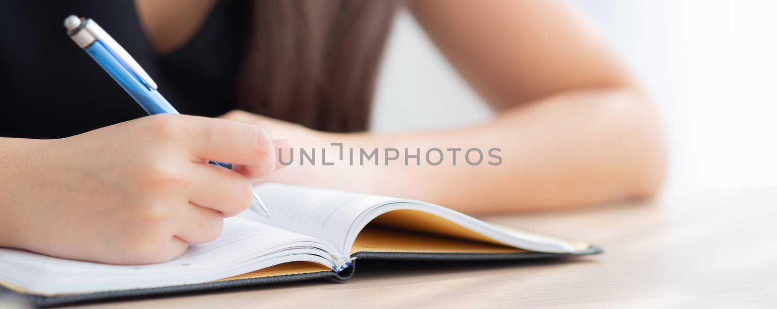 Closeup hand asian woman sitting study and learning writing notebook and diary on table at home, girl homework, business writer woman working on table, education concept, banner website.