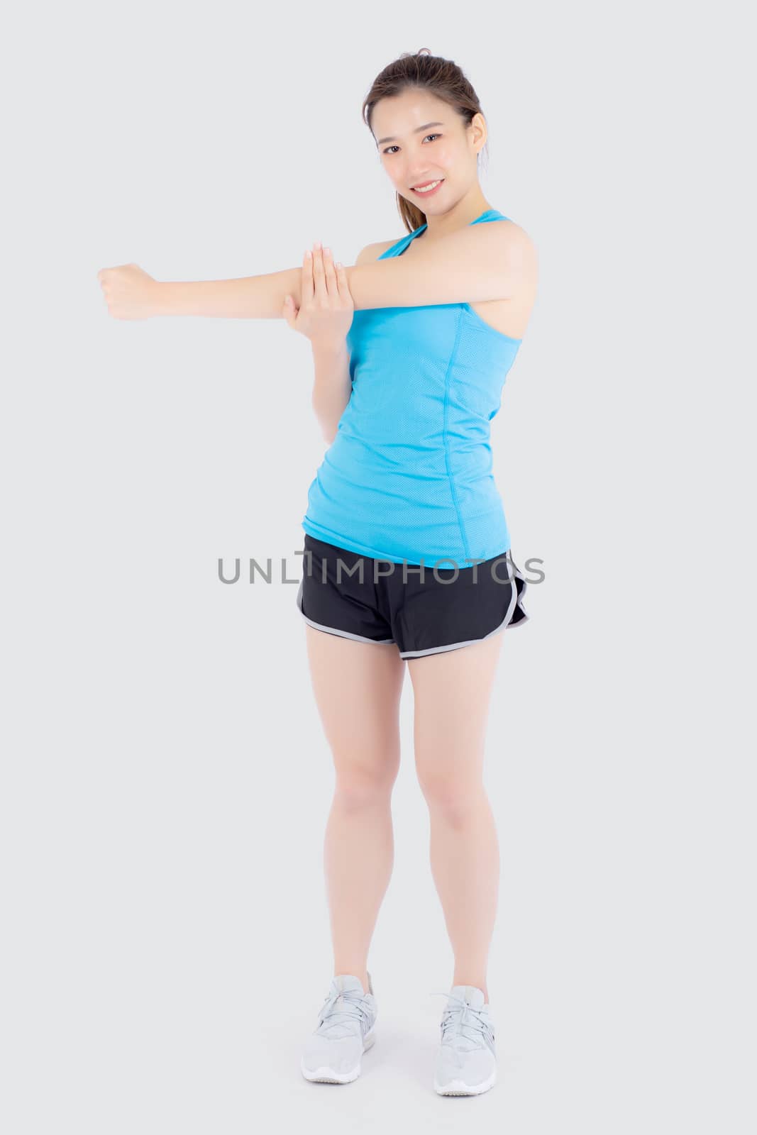 Beautiful portrait young asian woman happy standing stretch muscle arm isolated on white background, girl wear sport clothes smiling exercise yoga for health, healthy and wellness concept.