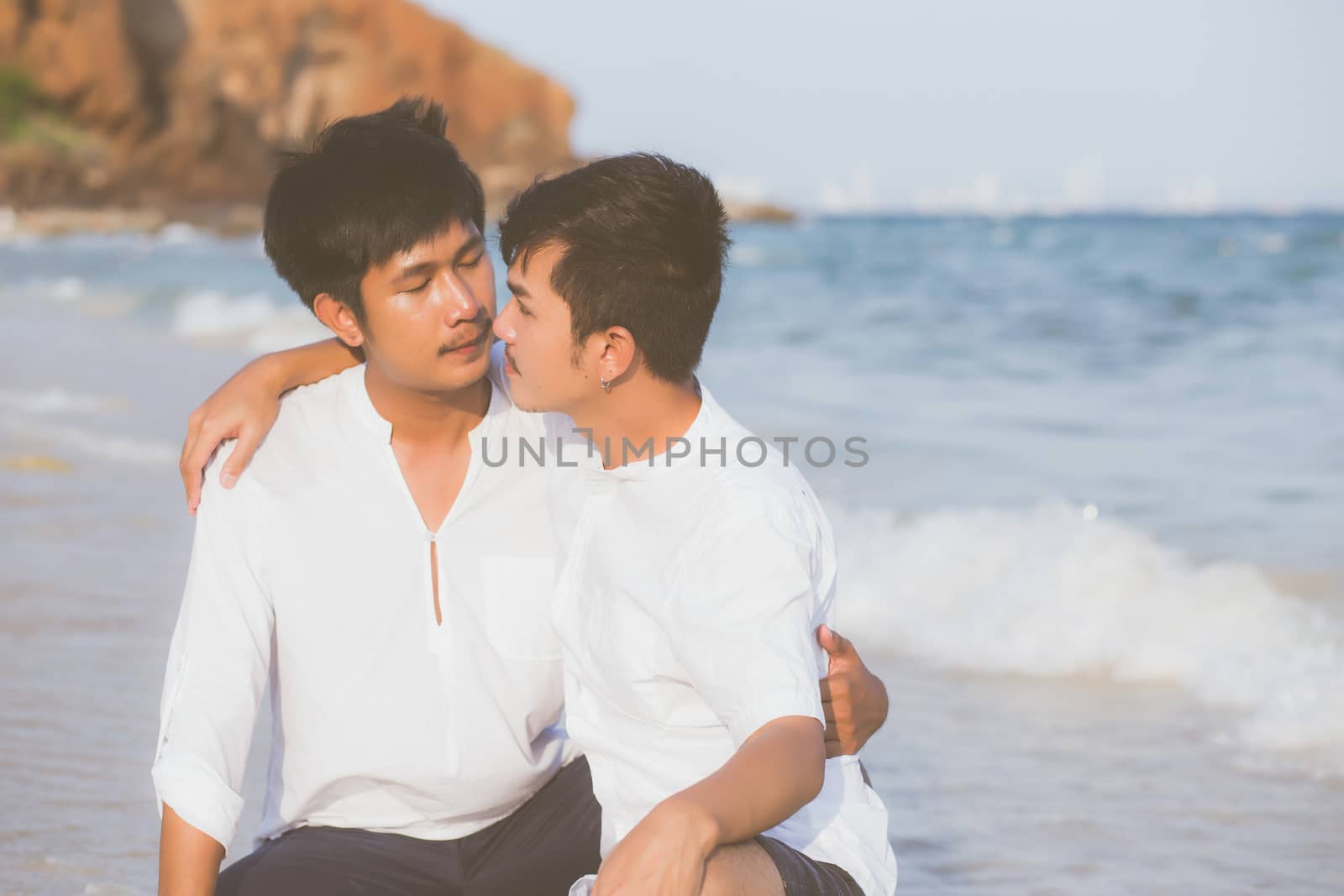 Homosexual portrait young asian couple sitting hug together on b by nnudoo