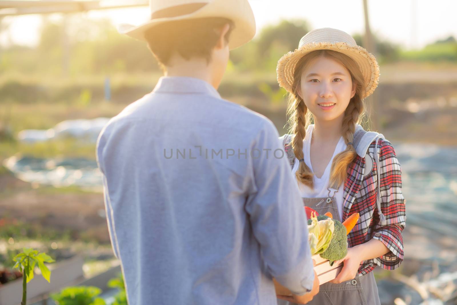 Beautiful young asian woman and man holding fresh organic vegeta by nnudoo