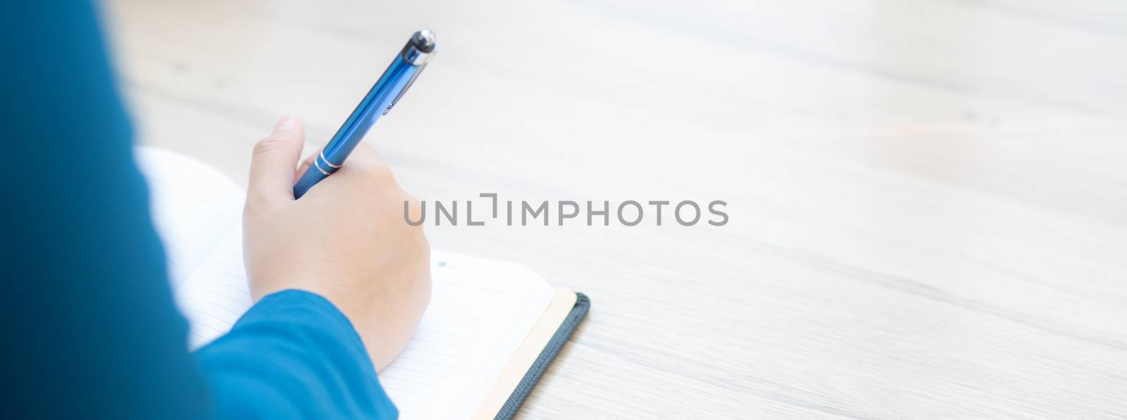 Closeup hand woman writer thinking idea and writing on notebook  by nnudoo