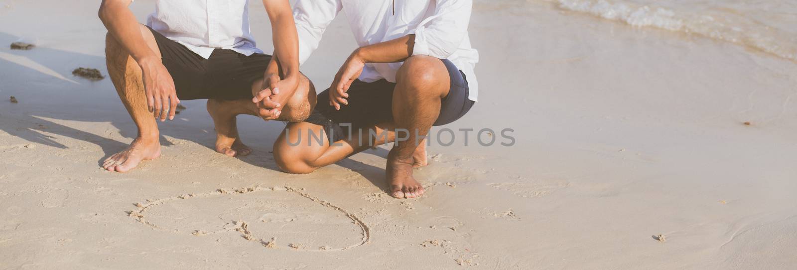 Young asian couple gay romantic drawing heart shape together on sand in vacation, homosexual happy and fun with love sitting on sand at the beach in travel summer, LGBT legal concept, banner website.