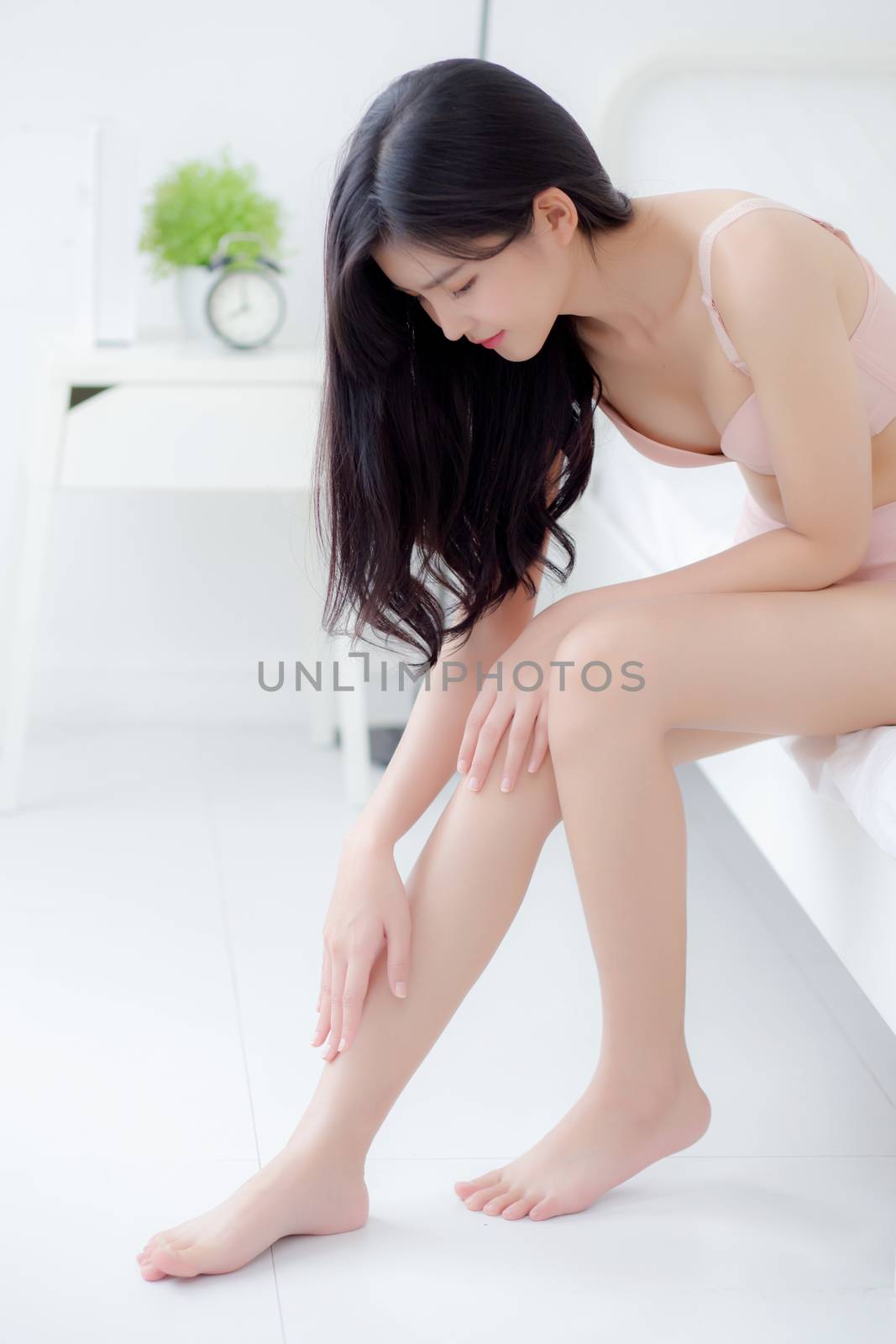 Beautiful young asian woman touch skin leg smooth with cream and by nnudoo