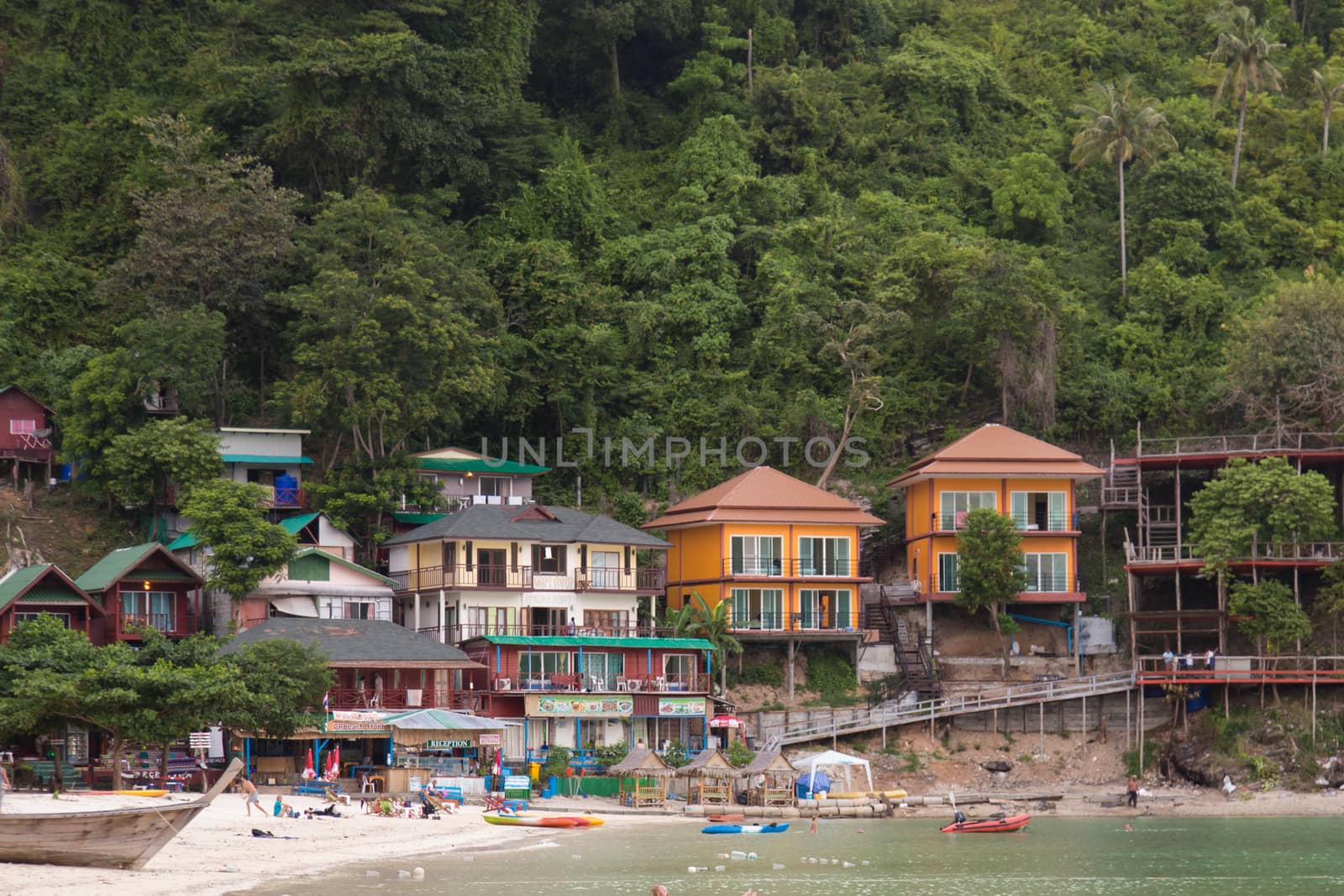 Phi Phi Thailand 12.6.2015 beachside buildings with tourists and boats by kgboxford