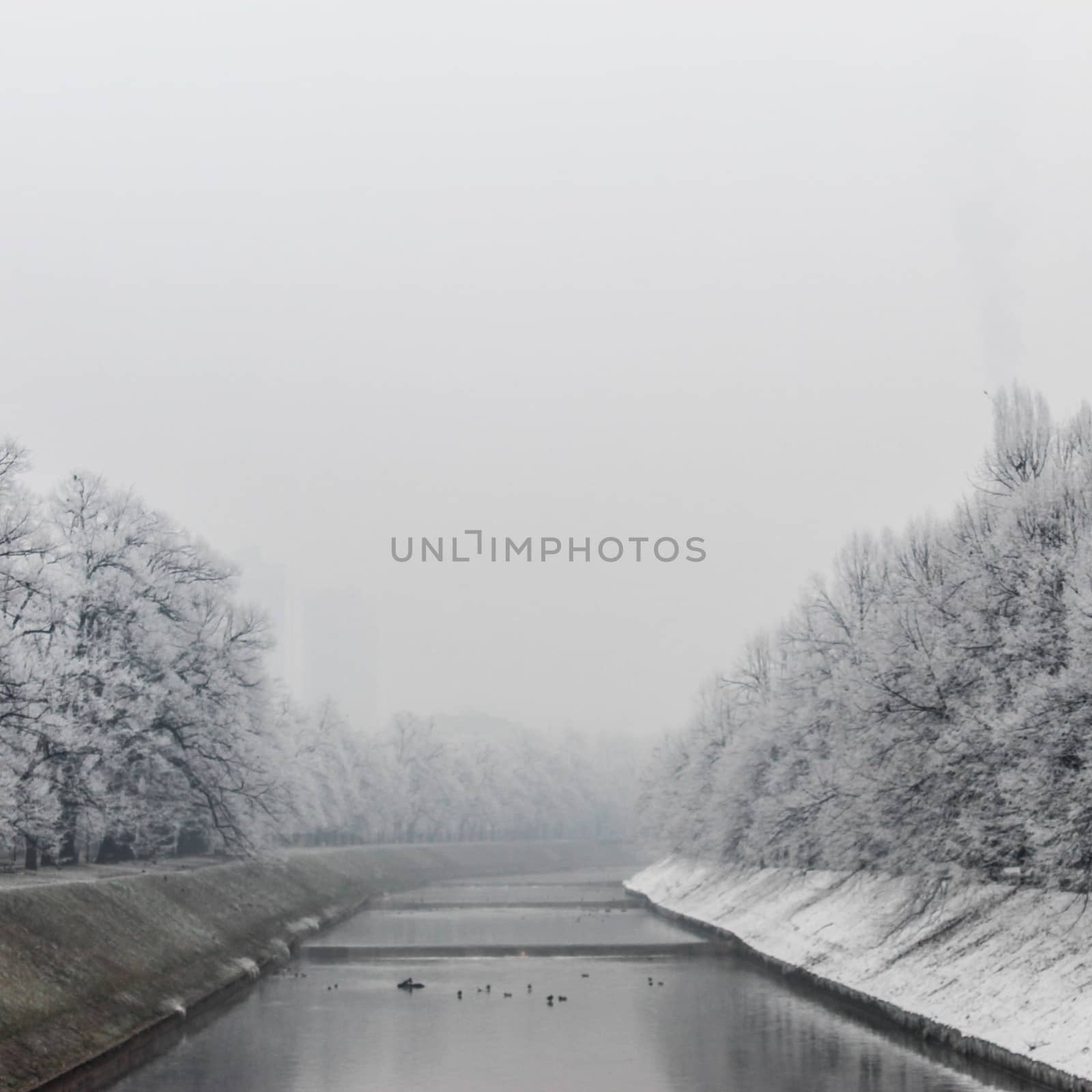Winter in Sarajevo. The Miljacka river in Sarajevo during the winter. In winter, Sarajevo has fog and pollution with little snow on the coast. by mahirrov
