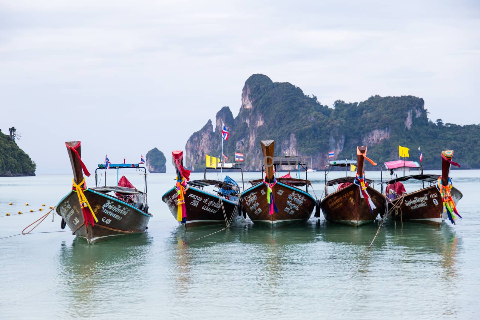 Phi Phi Thailand 12.6.2015 fishing boats in the bay with hills in the background by kgboxford