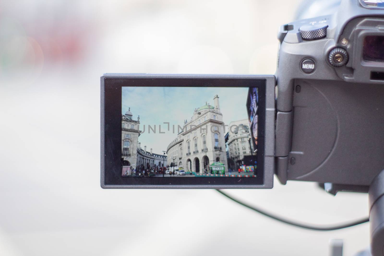 London, UK - February 14, 2020: Classic white buildings from Piccadilly Circus on screen of digital camera. Camera capturing a cityscape from London. Photography and video equipment