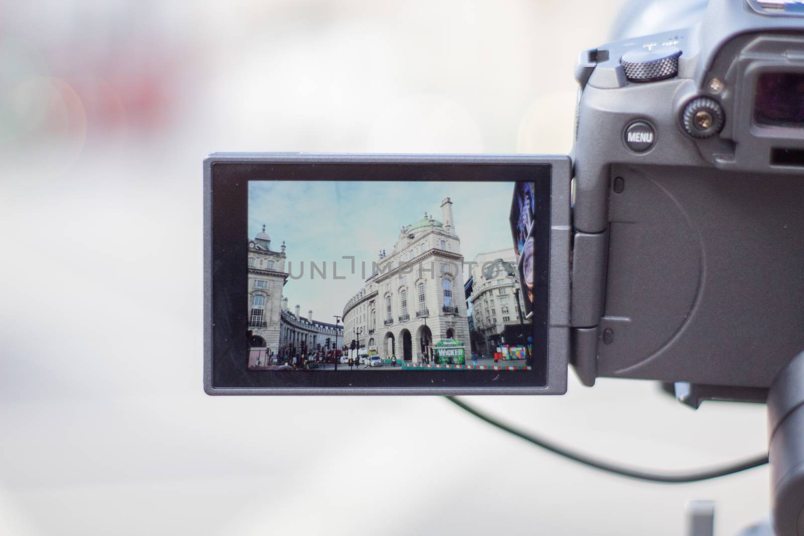 London, UK - February 14, 2020: Classic white buildings from Piccadilly Circus on screen of digital camera. Camera capturing a cityscape from London. Photography and video equipment