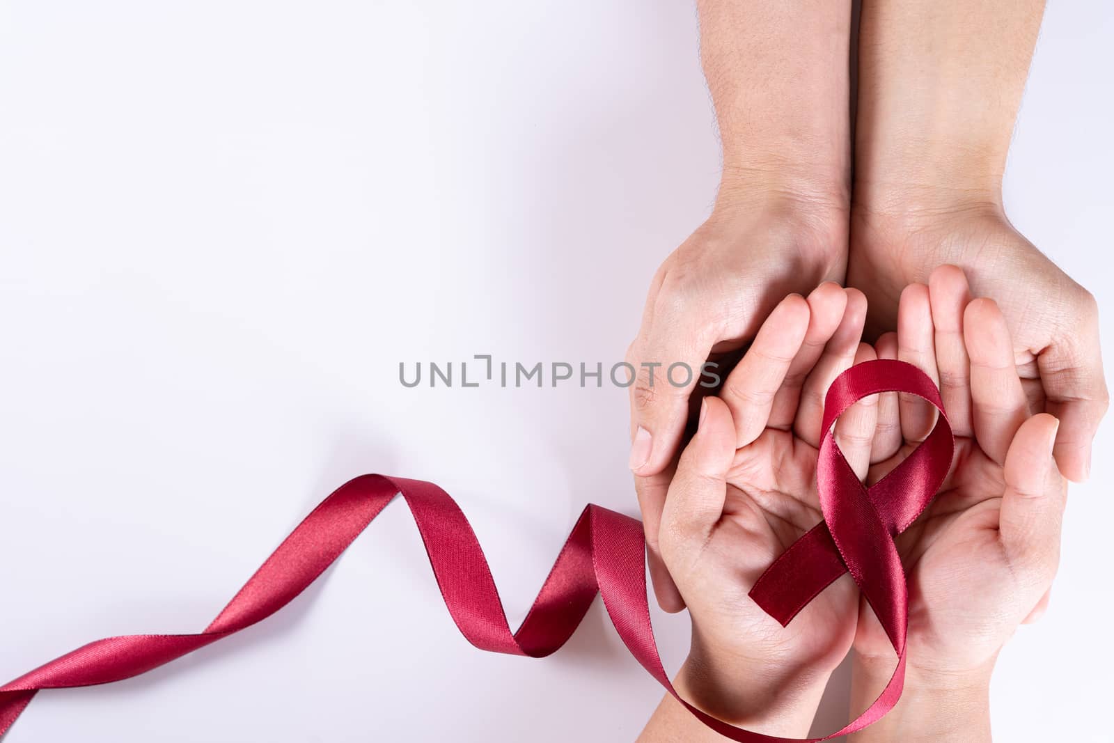 Aids awareness, man and woman hands holding red ribbon on white background with copy space for text. World Aids Day, Healthcare and medical concept. by mikesaran