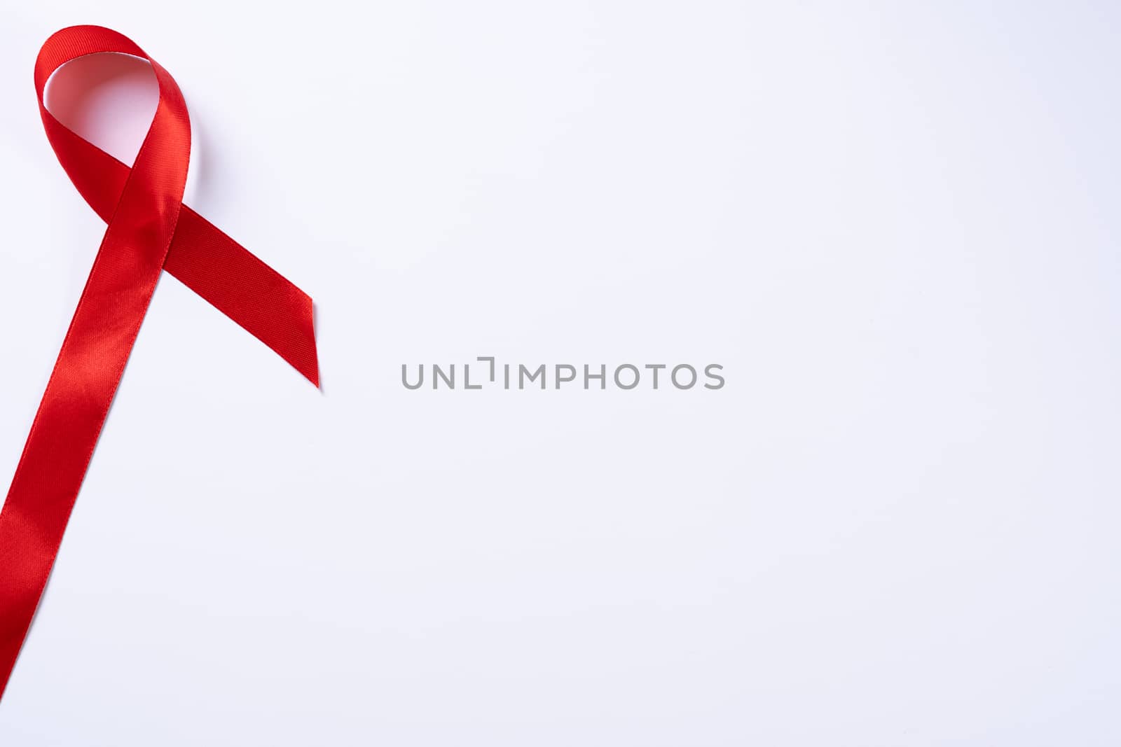 Aids awareness, red ribbon on white background with copy space for text. World Aids Day, Healthcare and medical concept.