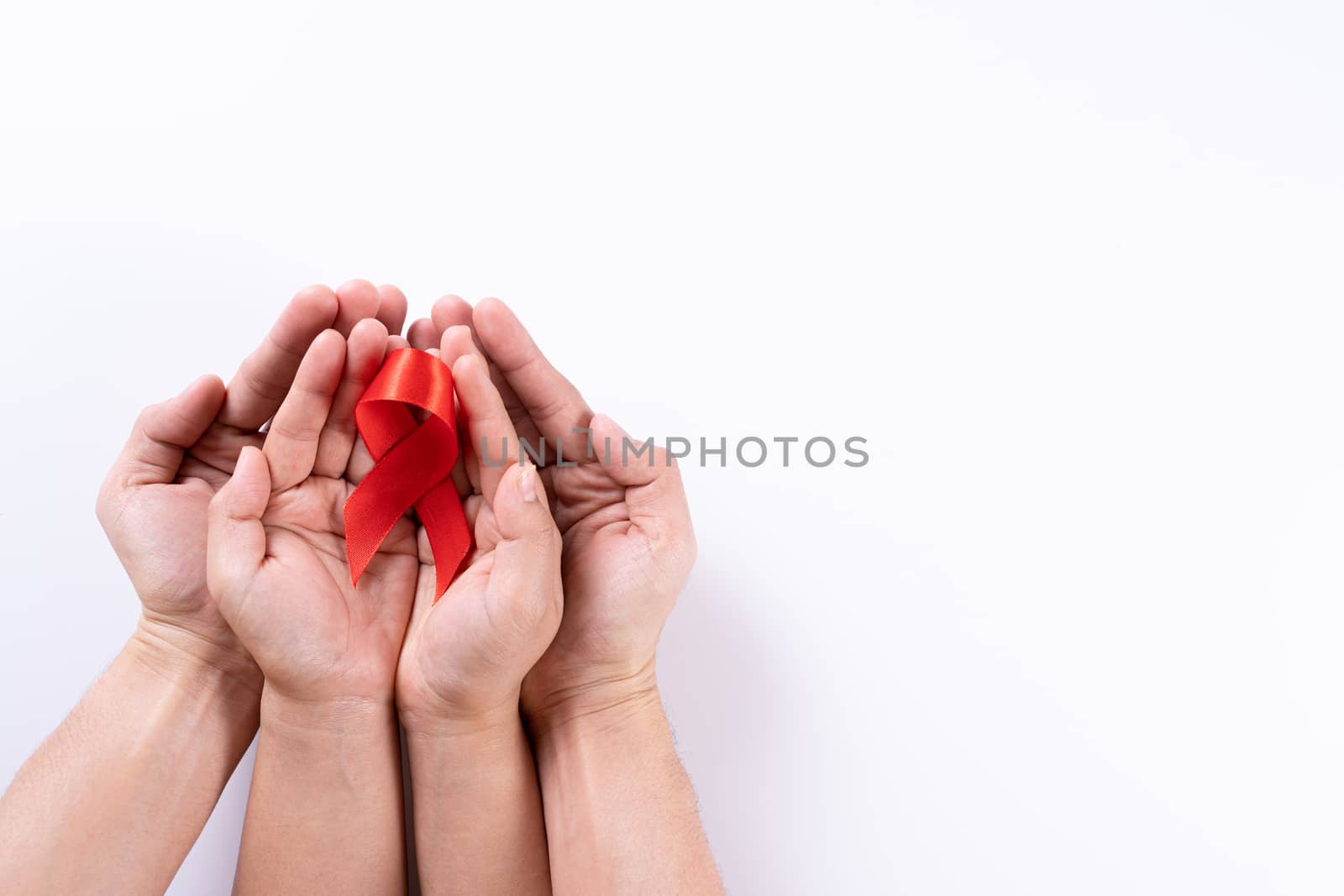 Aids awareness, man and woman hands holding red ribbon on white background with copy space for text. World Aids Day, Healthcare and medical concept.