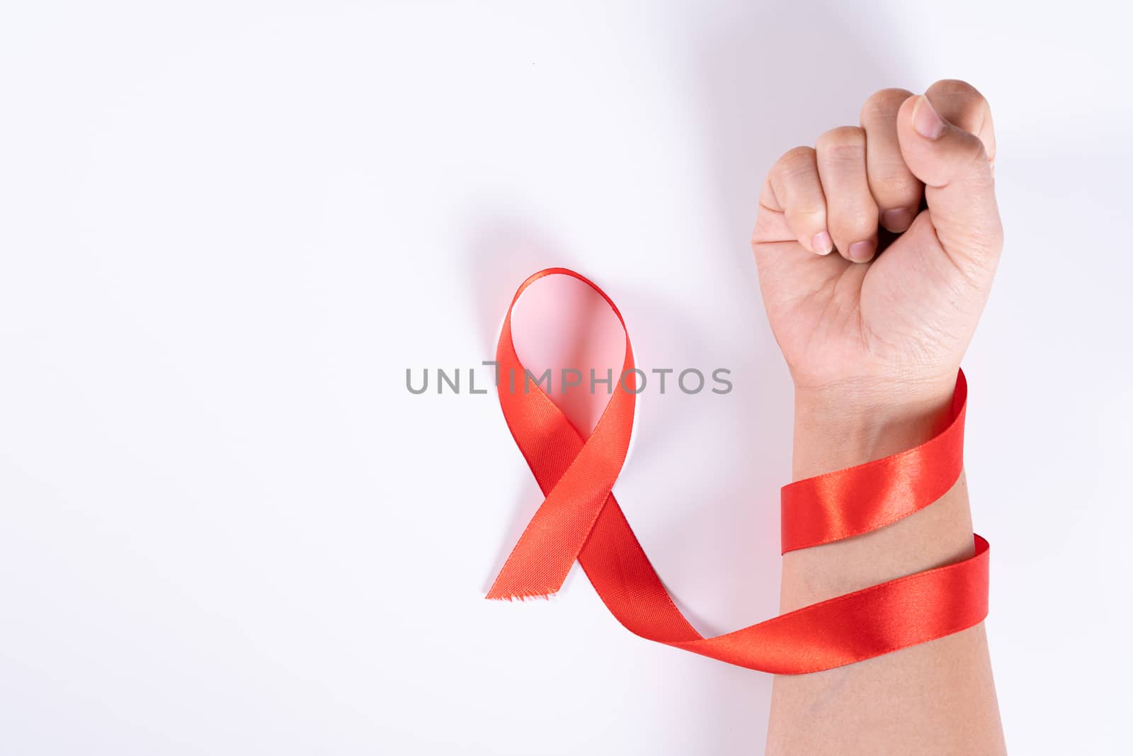 Aids awareness, woman hands holding red ribbon on white background with copy space for text. World Aids Day, Healthcare and medical concept. by mikesaran