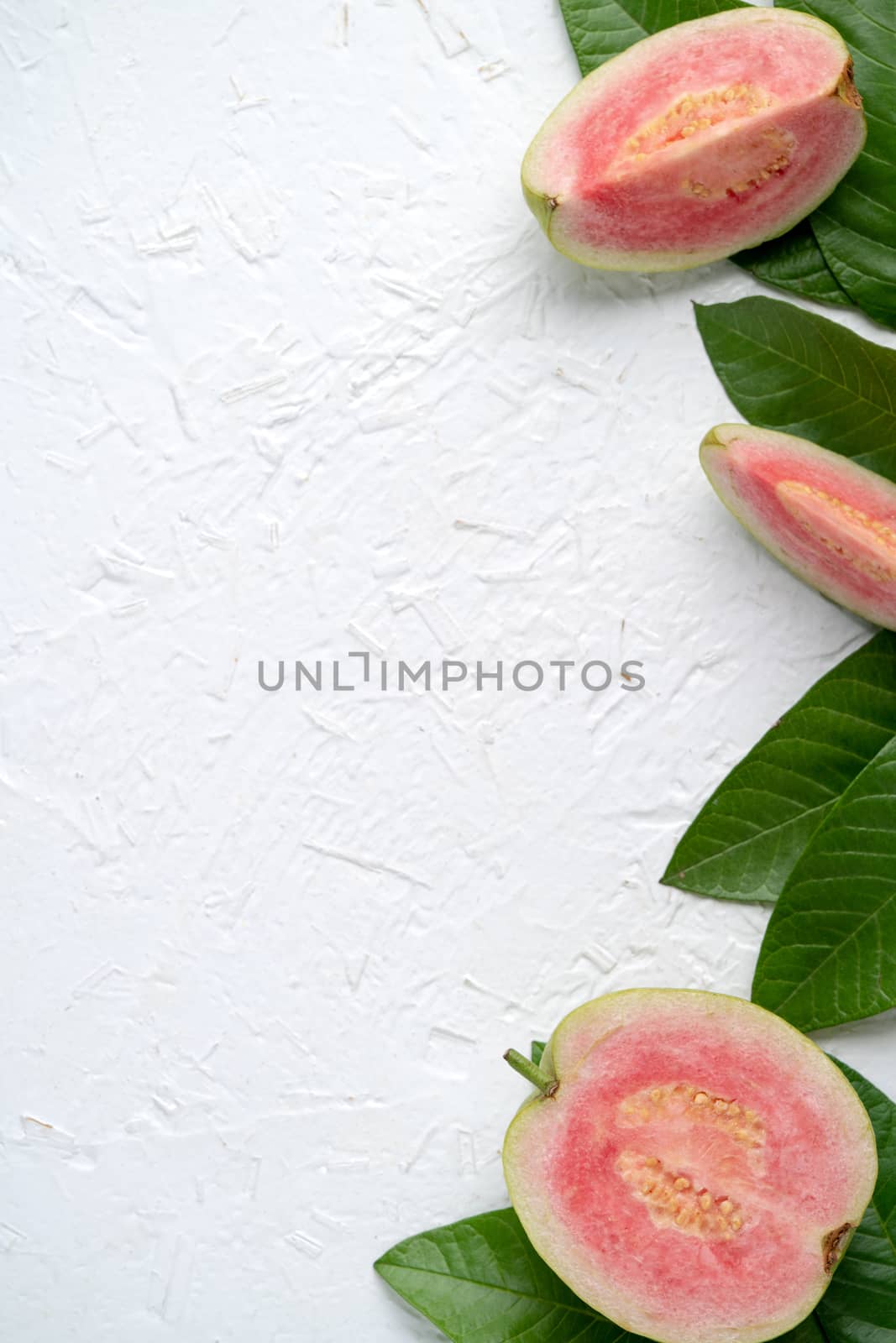 Top view, flat lay of delicious beautiful Red guava with fresh green leaves isolated on white table background, studio overhead table shot with copy space.