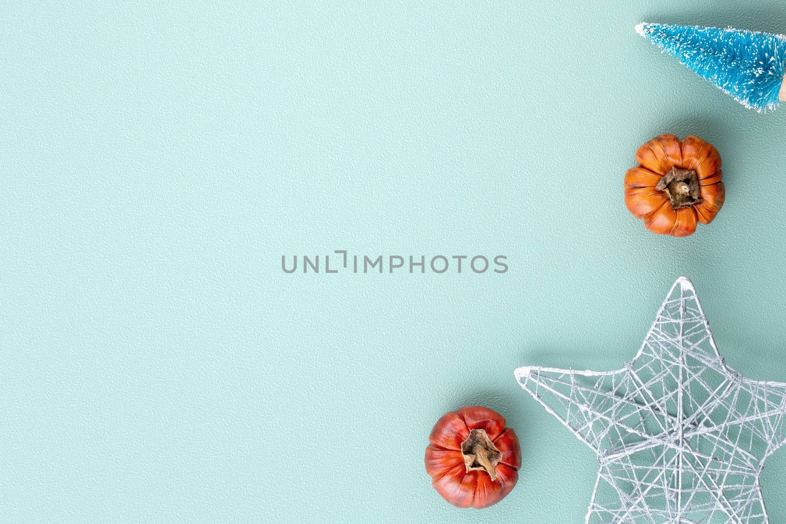 Top view of Christmas holiday decoration ornament composition with Christmas tree, gift star, gingerbread man flat lay with copy space isolated on green background.