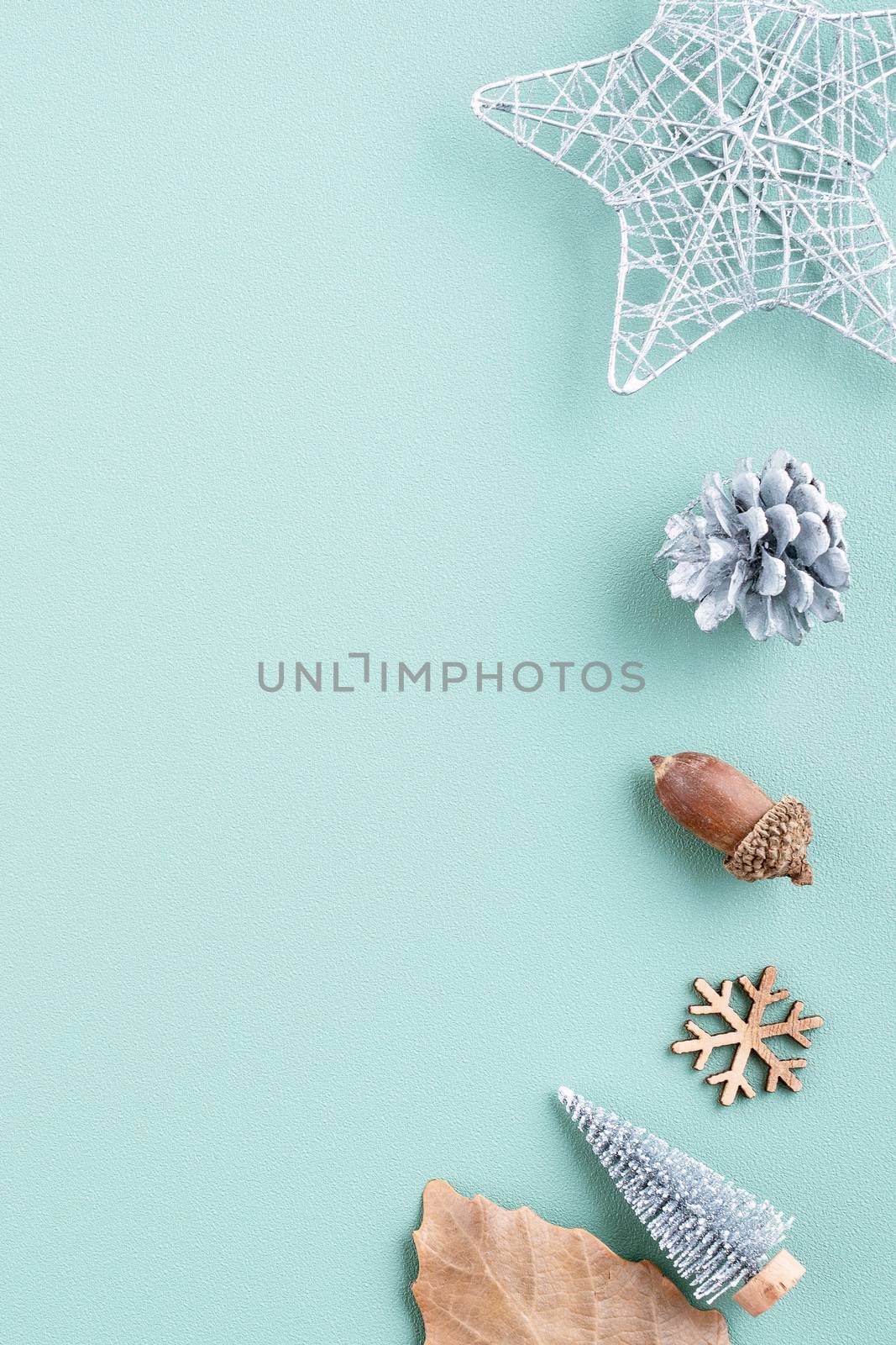 Top view of Christmas holiday decoration ornament composition with Christmas tree, gift star, gingerbread man flat lay with copy space isolated on green background.
